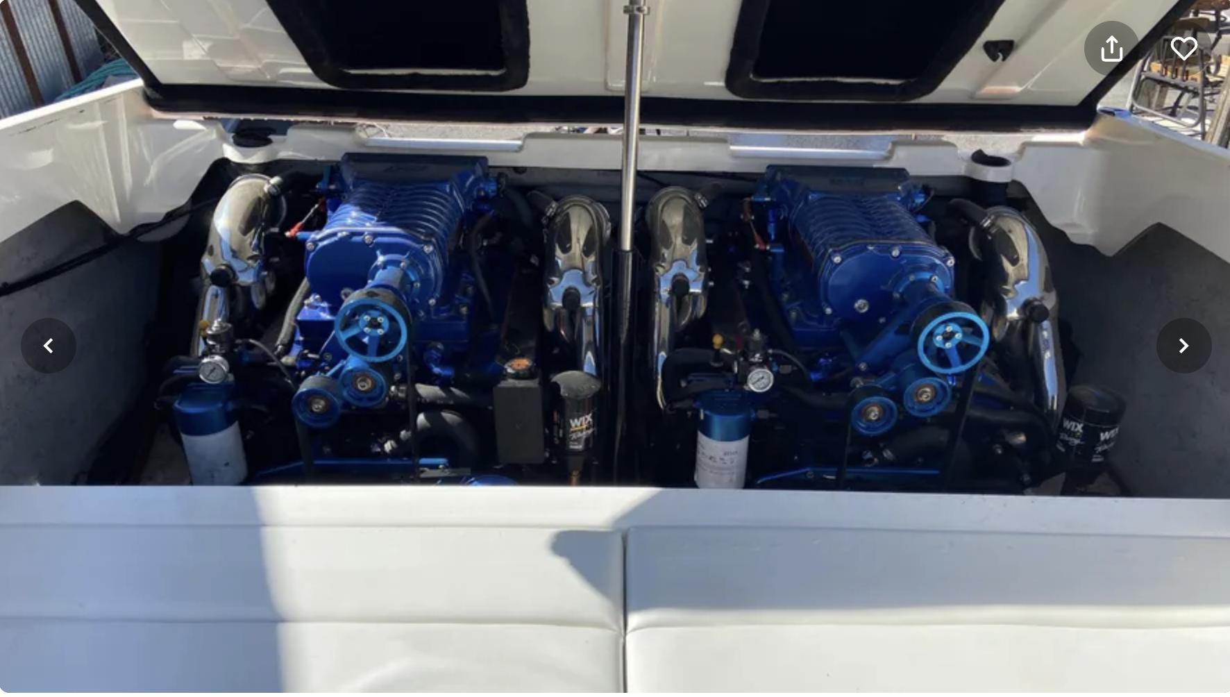 Twin engines in a 2002 Advantage Victory boat, featuring blue components and open engine compartment.