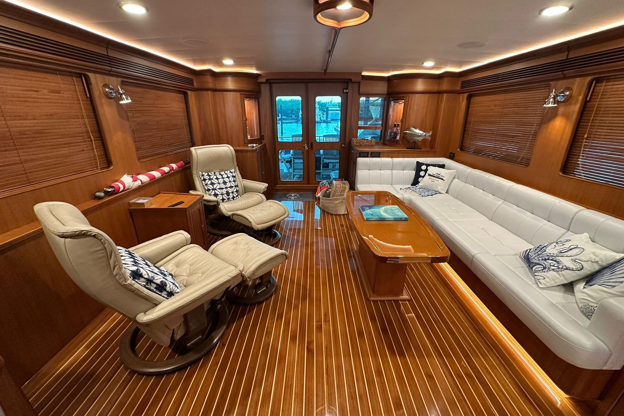Luxurious interior of 2023 Marlow Explorer 66E-CB yacht with elegant wood finishes and plush seating.