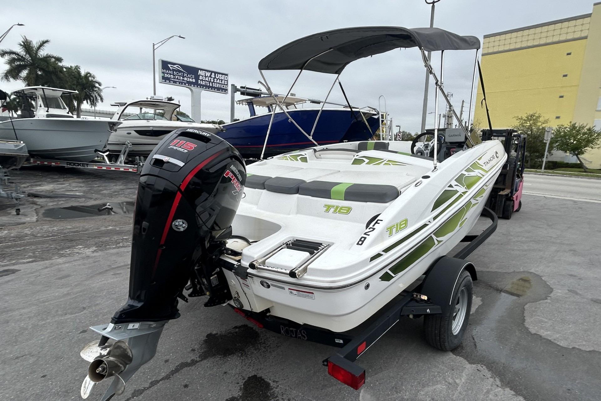 2022 Tahoe T18 boat with Mercury 115 engine on trailer, parked outdoors.