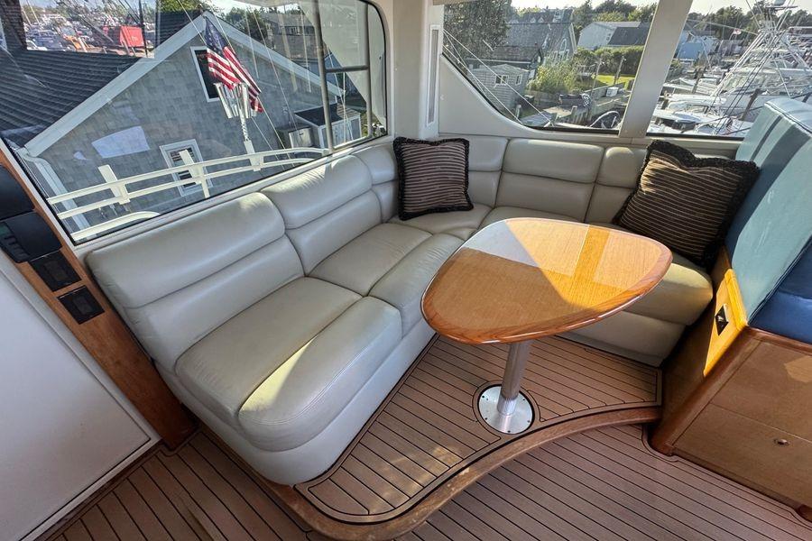 Luxurious interior of 2002 Viking 61 Enclosed Bridge yacht with leather seating and wooden table.