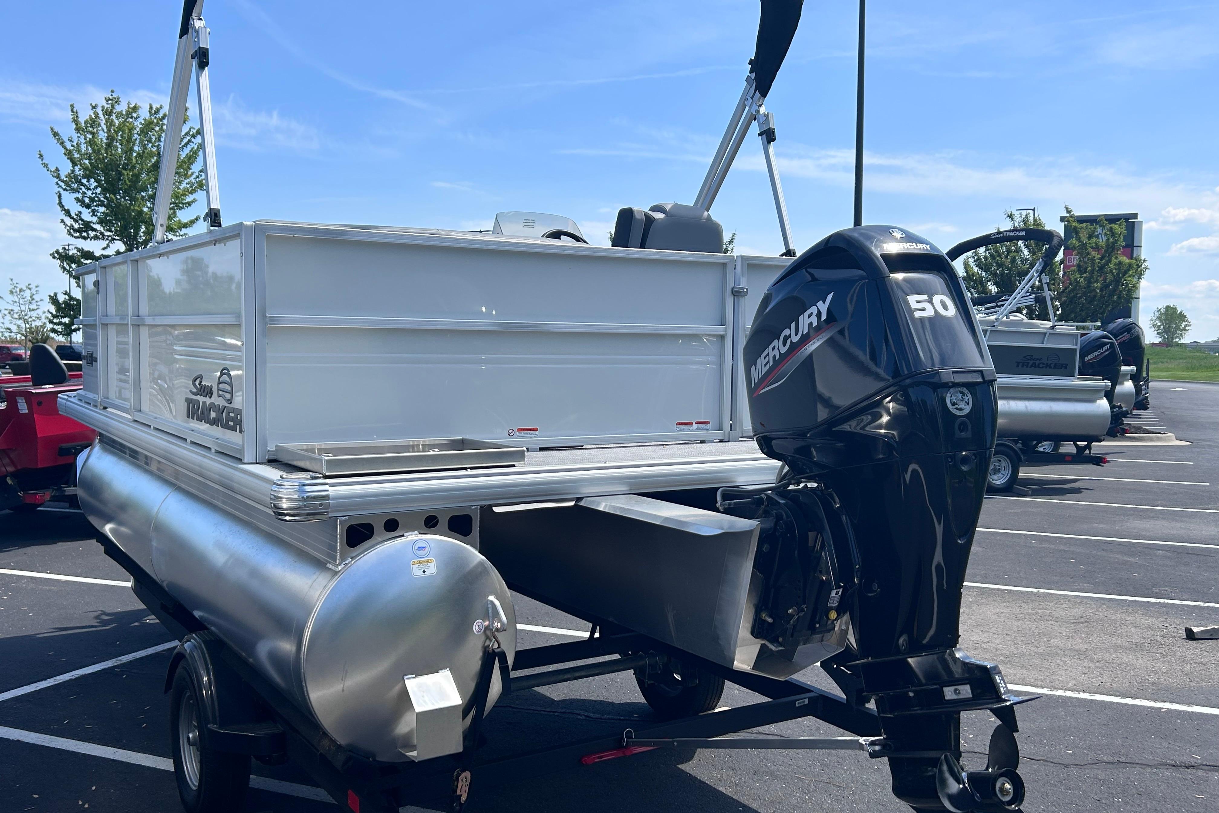 2026 Sun Tracker Party Barge 16 DLX pontoon boat with Mercury 50 engine in parking lot.