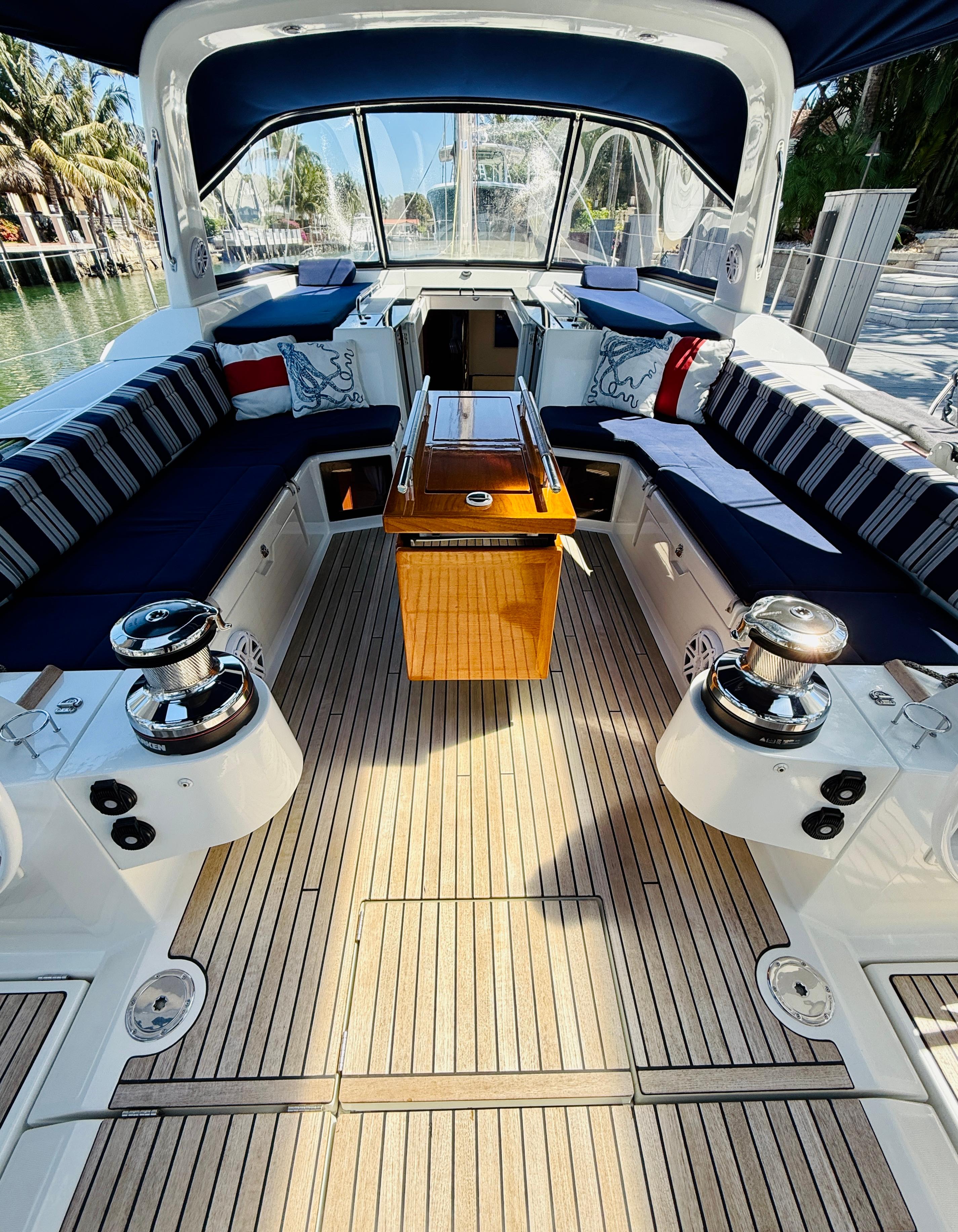 Spacious cockpit of 2015 Beneteau Oceanis 55 yacht with elegant seating and wooden table.