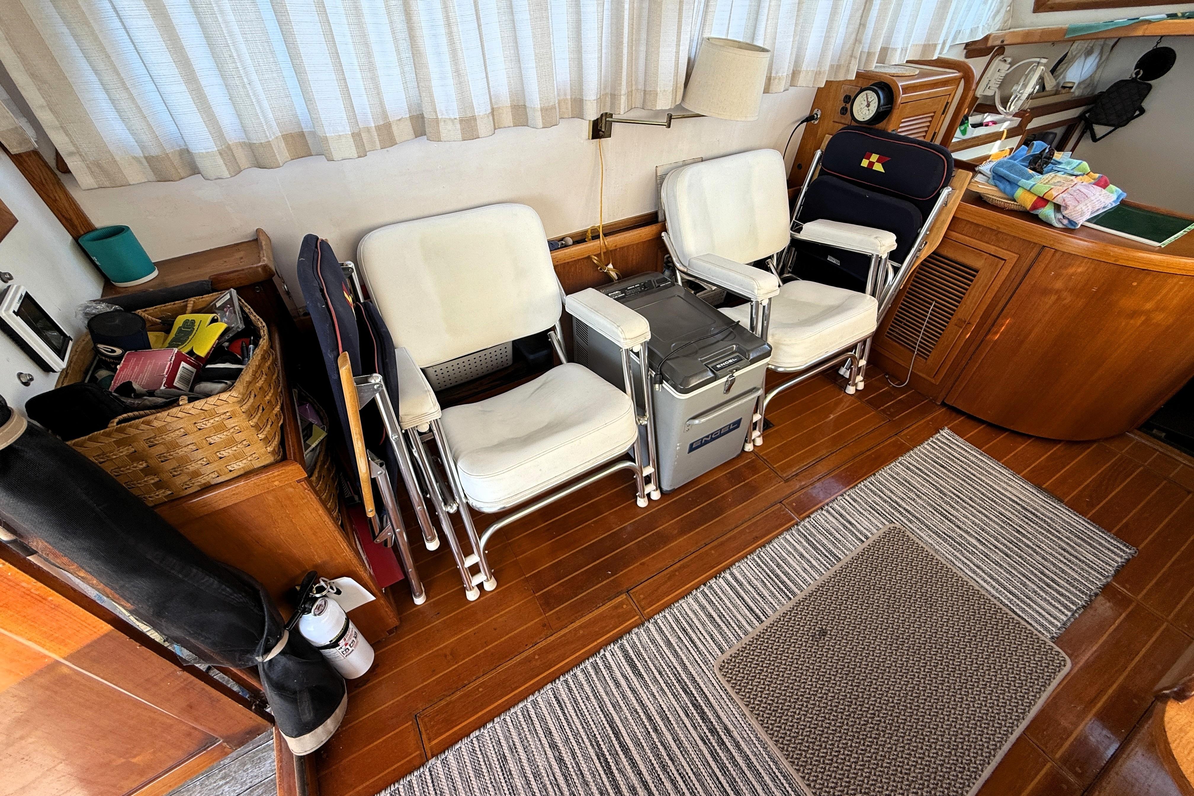 Interior of 1983 Wilbur 34 Fly Bridge Cruiser with chairs and wooden flooring.