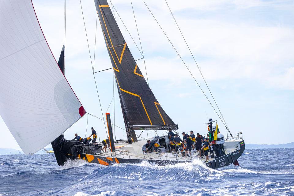 Sailing yacht Volvo Ocean 65 racing on open sea, crew in action, 2013 model.