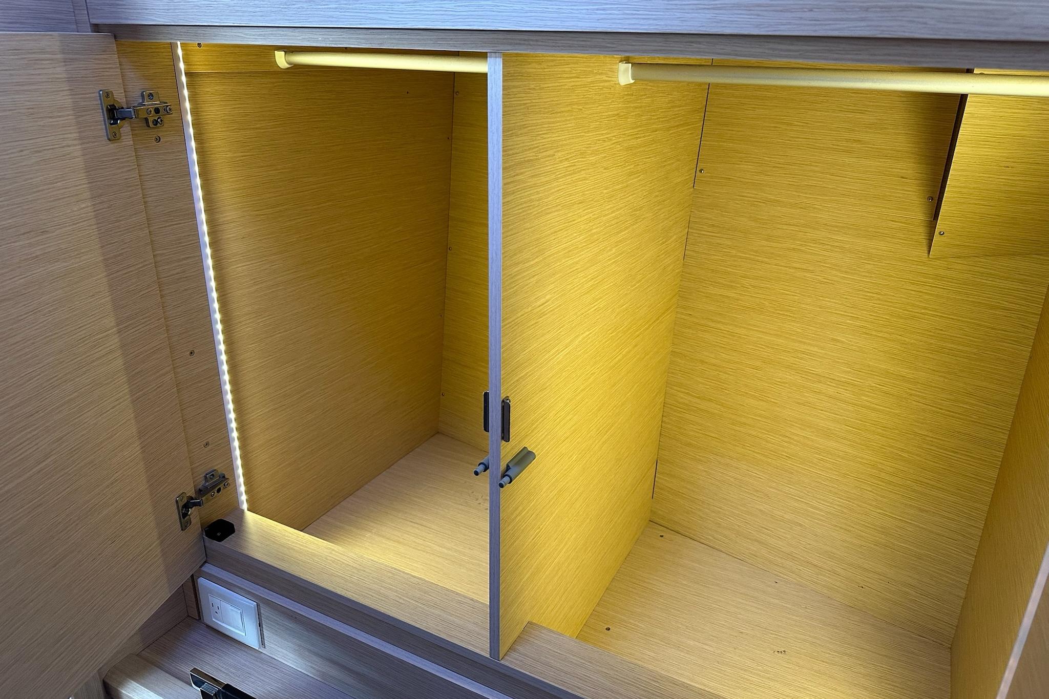 Empty wooden cabinet with LED lighting inside a 2018 Jeanneau 51 yacht.