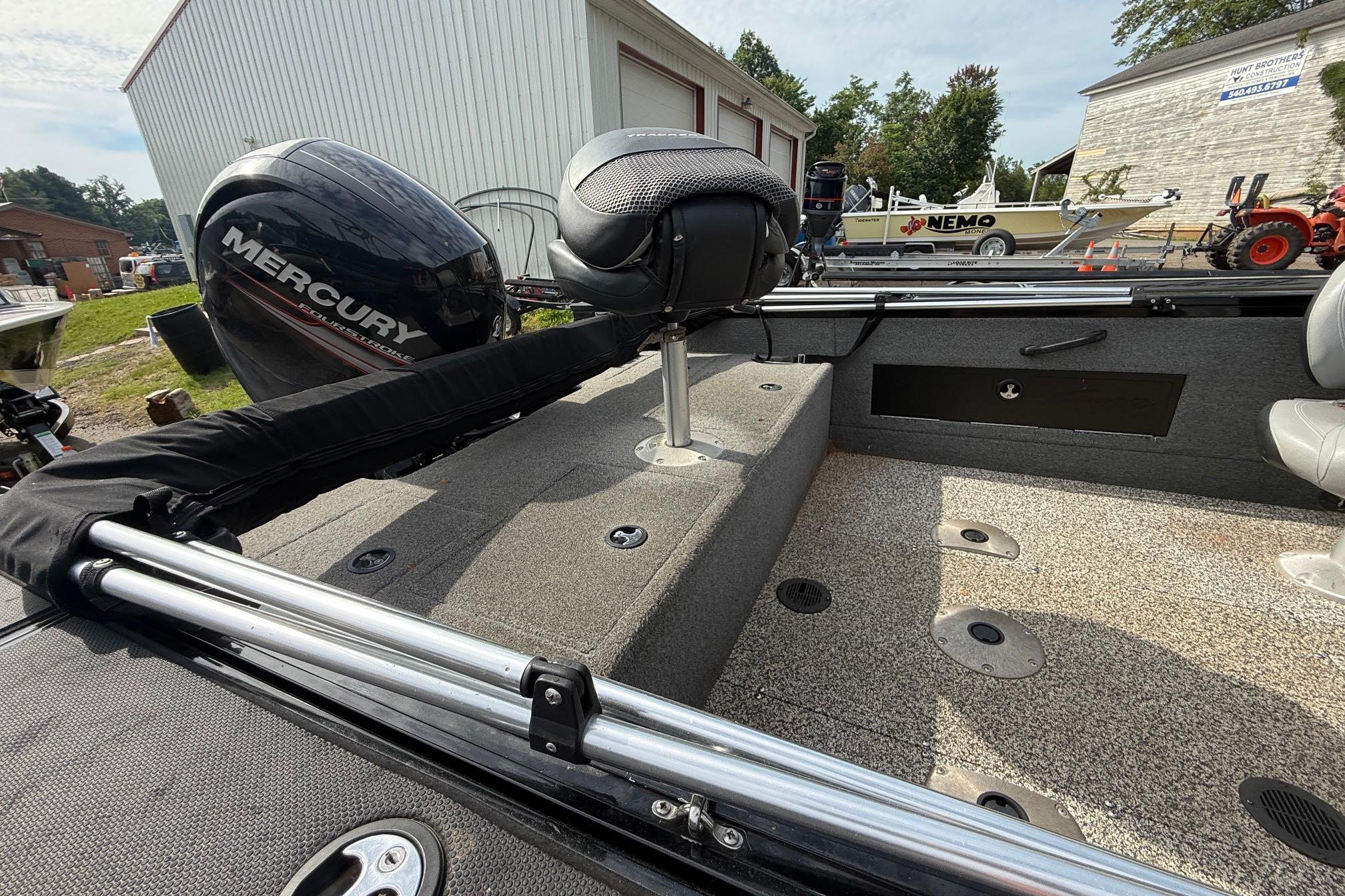 2016 Tracker Targa V-18 WT boat interior with Mercury engine, parked near buildings.