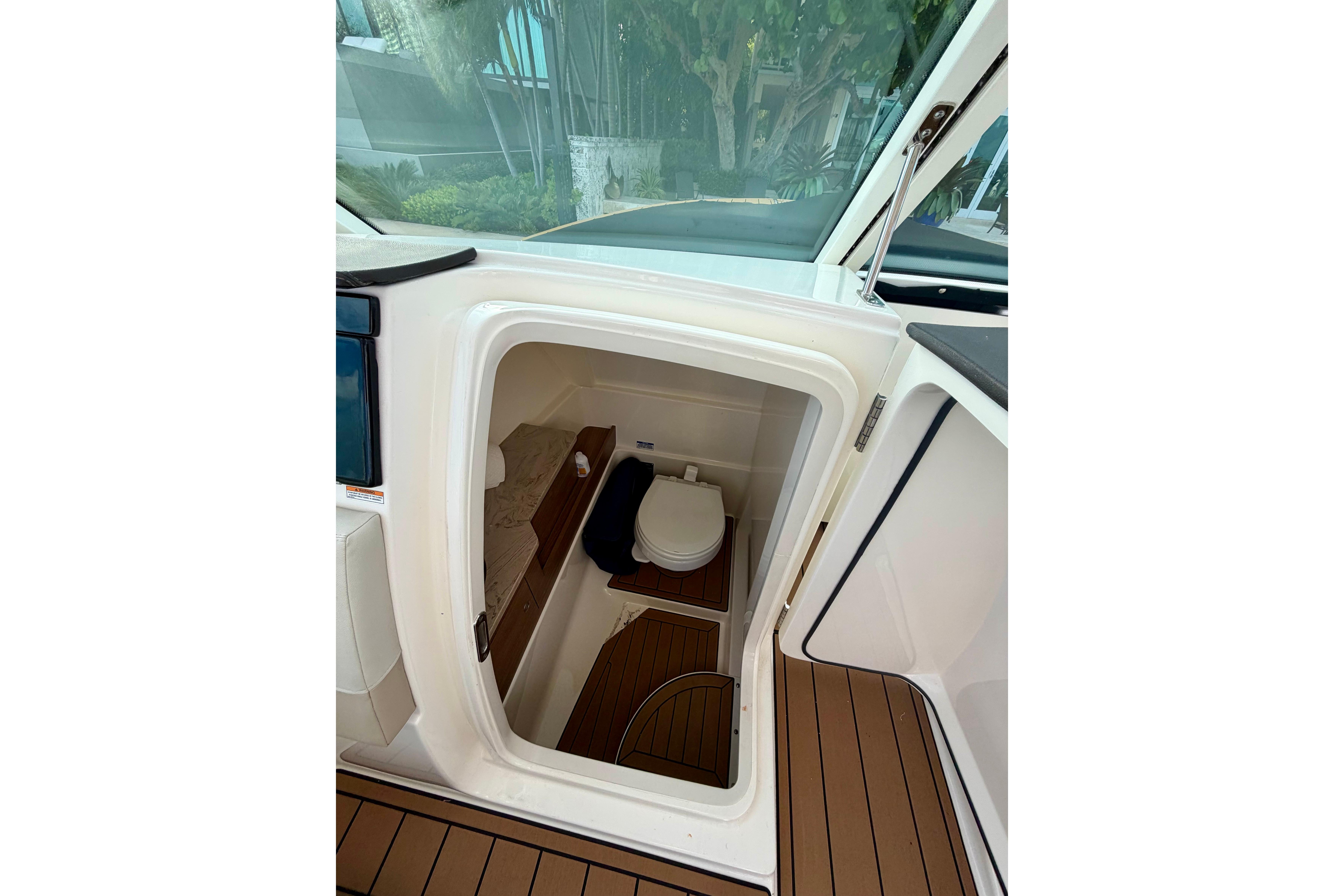 2022 Boston Whaler 280 Vantage boat interior with compact marine toilet.