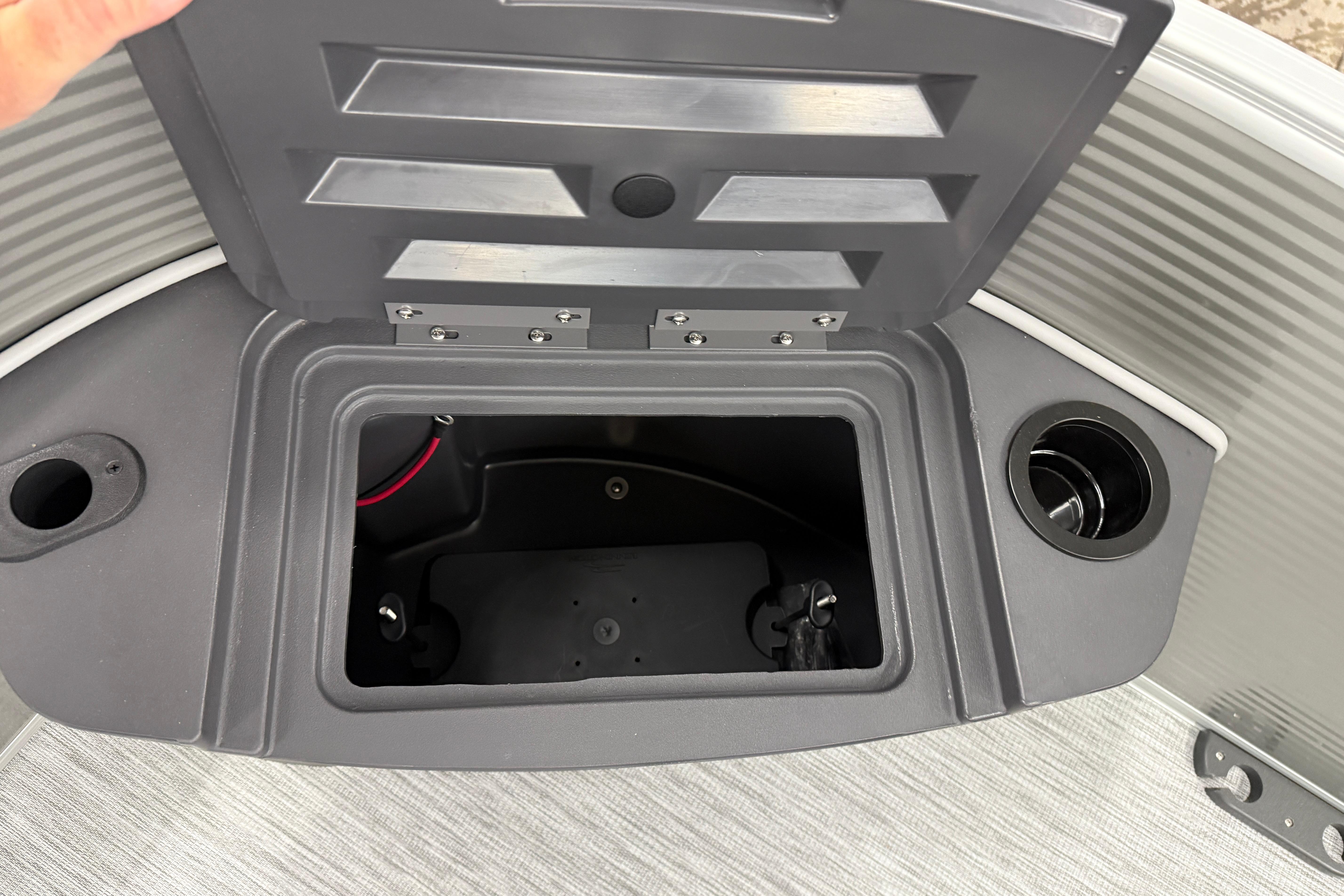 Open storage compartment on 2026 Bennington 20 SF boat with cup holders.