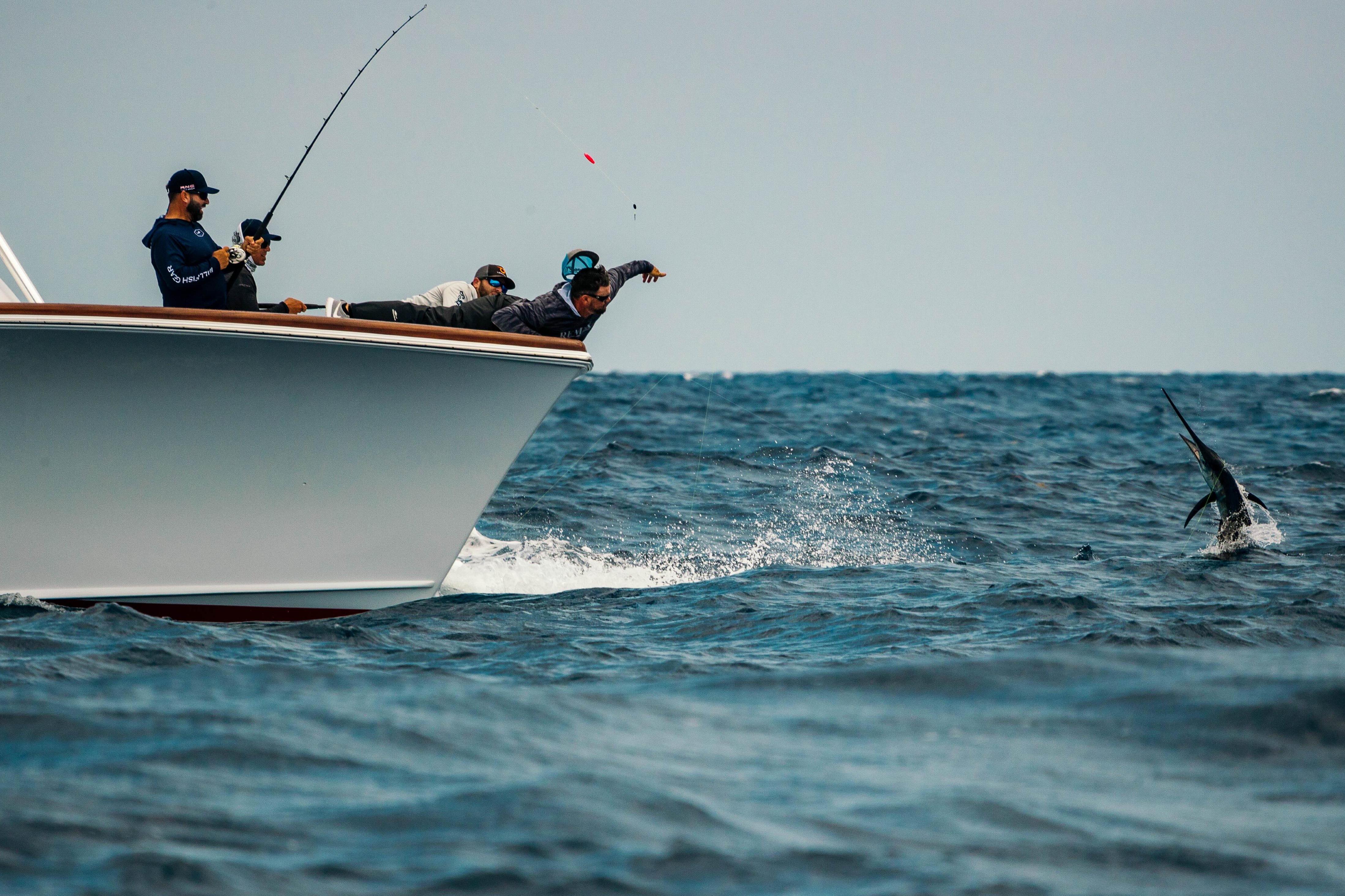 Fishing on a 2026 Release Boatworks 46 Walkaround, anglers catch a leaping fish in open ocean.