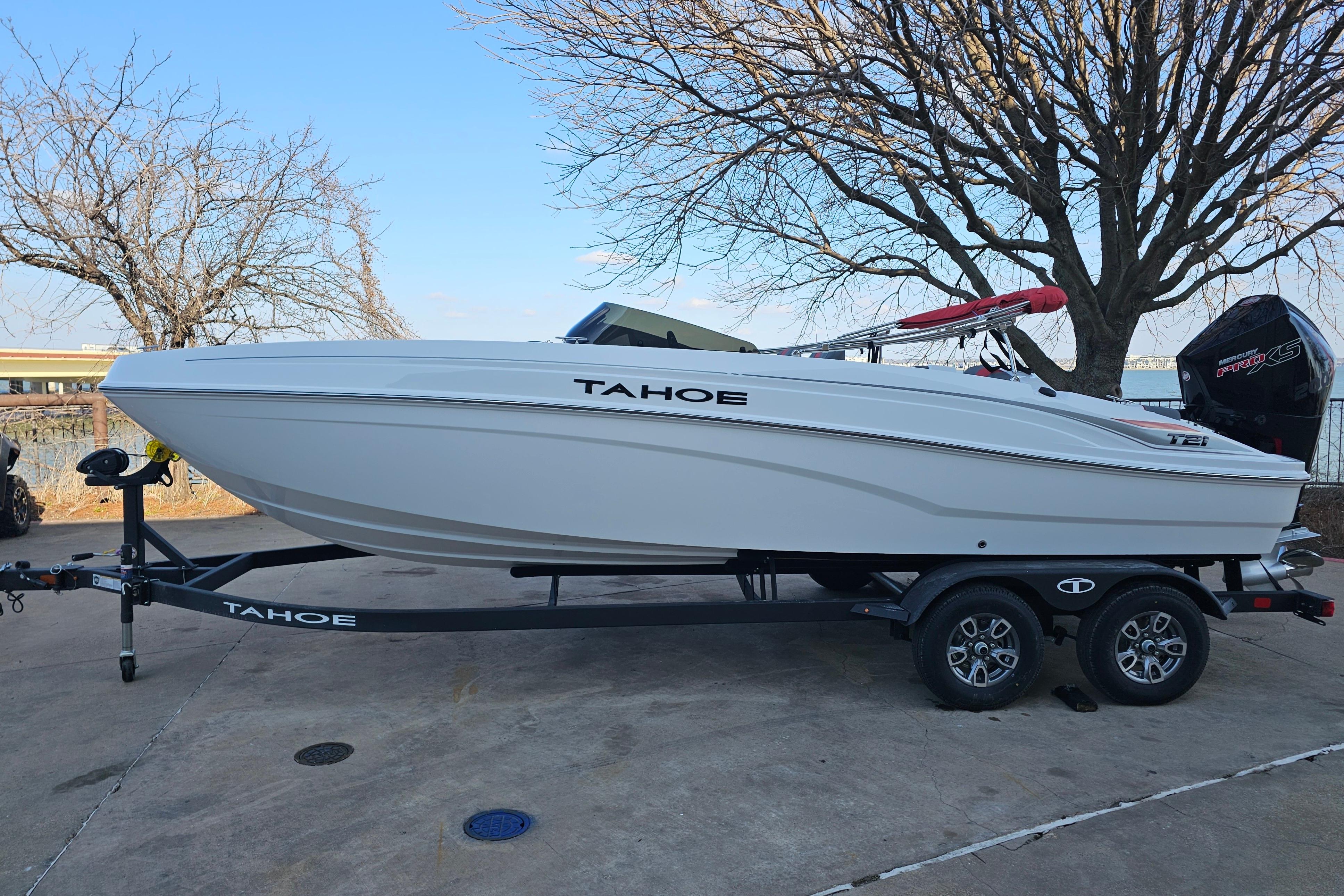 2026 Tahoe T21 boat on trailer, parked outdoors near trees.