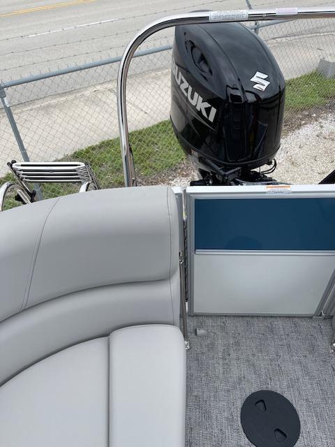 2025 Berkshire 22 RFX LE Tri-toon Pontoon with Suzuki outboard motor, gray seating, and carpeted deck.