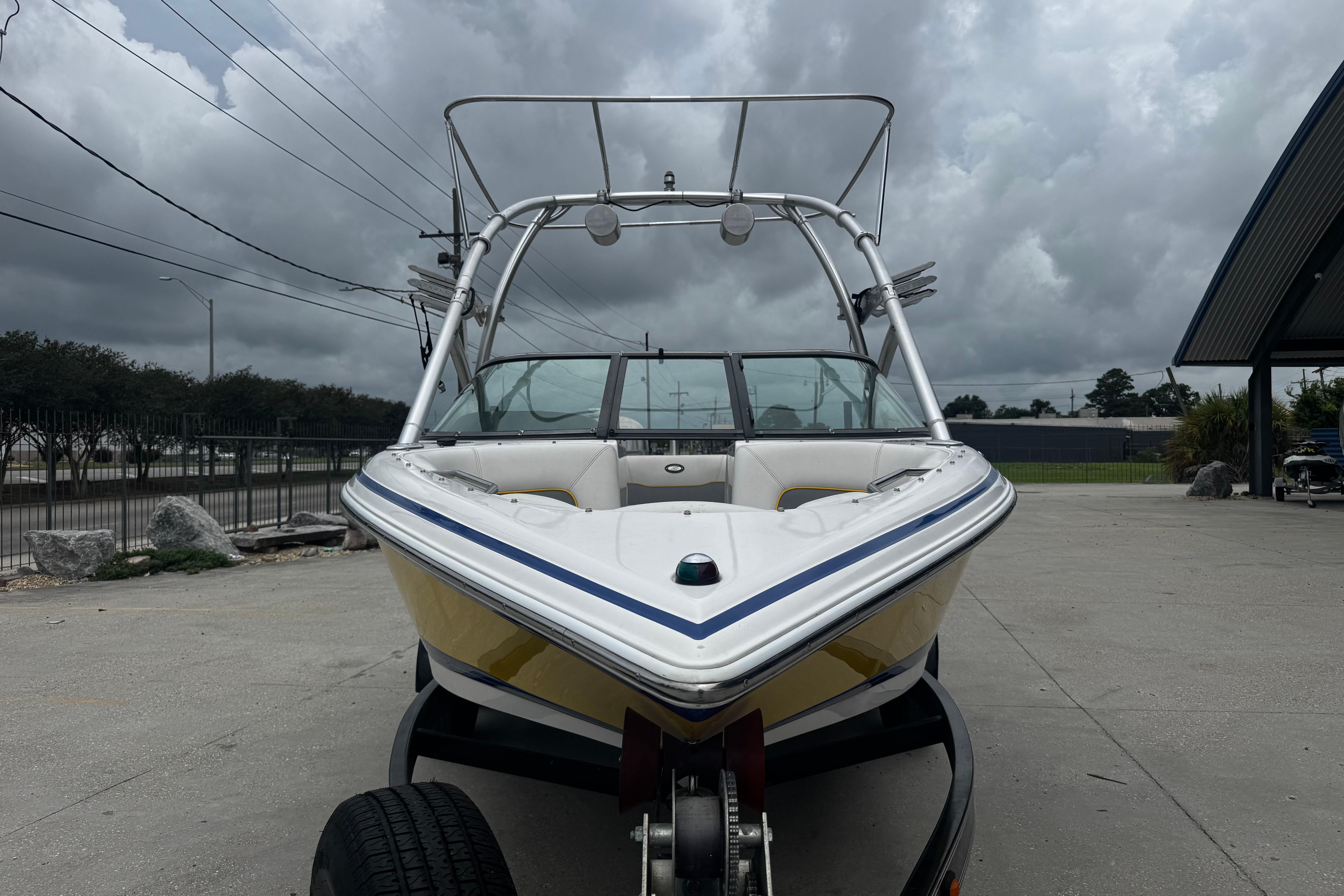 2006 Supra Launch 22 SSV boat on trailer under cloudy sky.