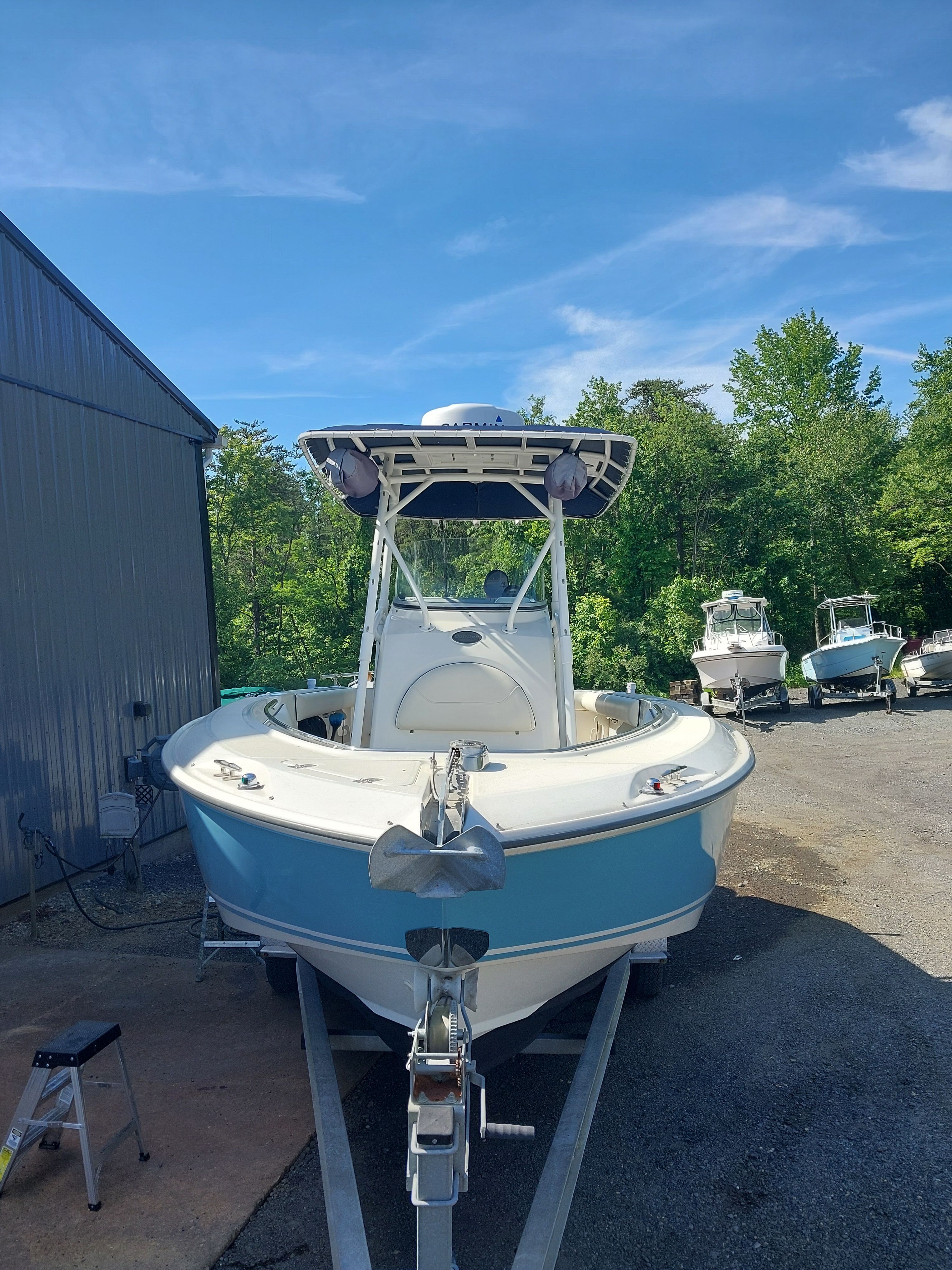 A 2005 Boston Whaler 240 Outrage on a trailer beside a building.