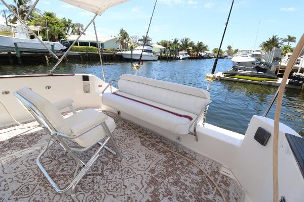 1992 Sea Ray 350 Express Bridge boat deck with seating, docked by waterfront homes.