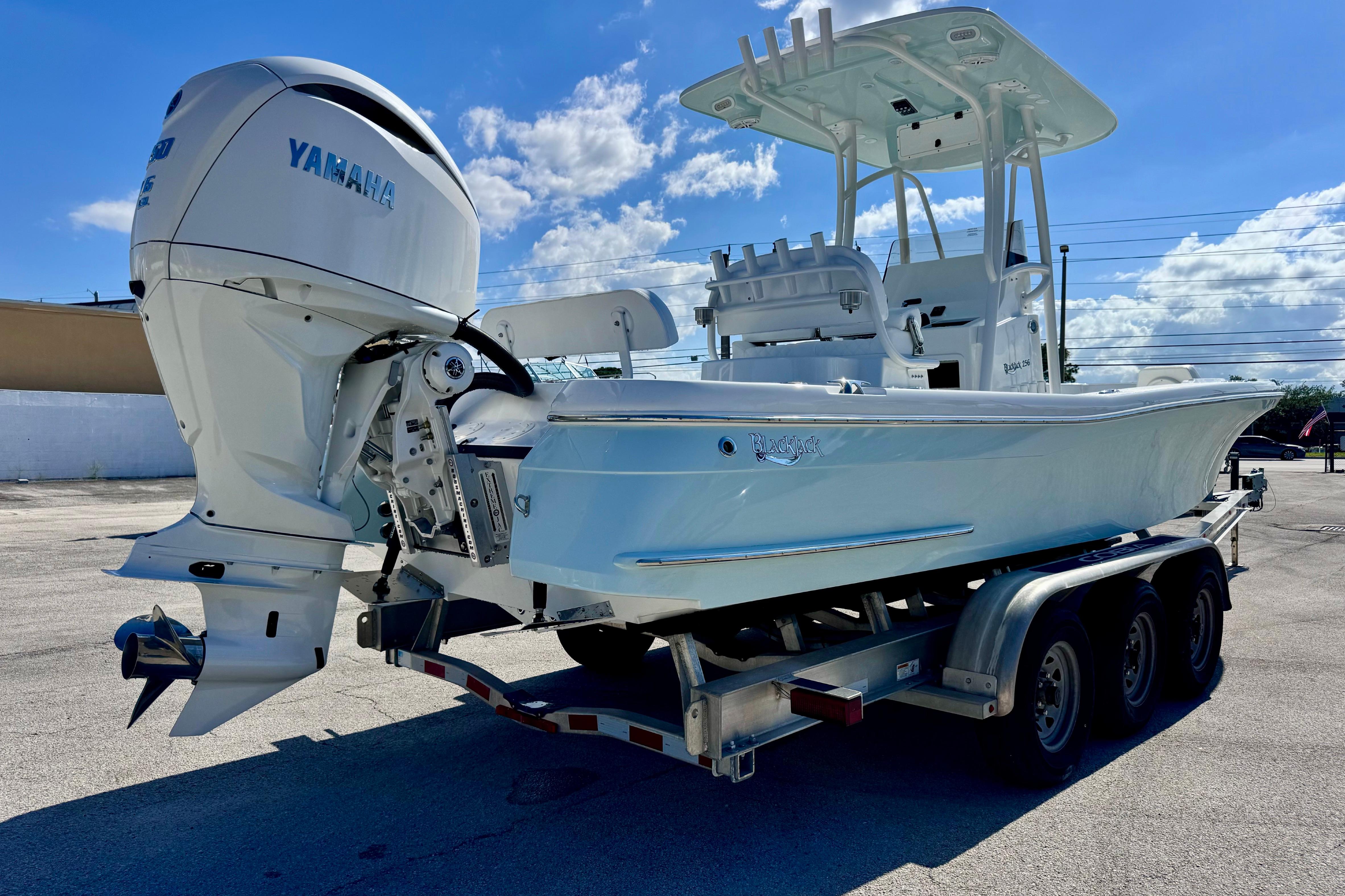 2026 BlackJack 256 Coastal boat on trailer with Yamaha outboard motor under blue sky.