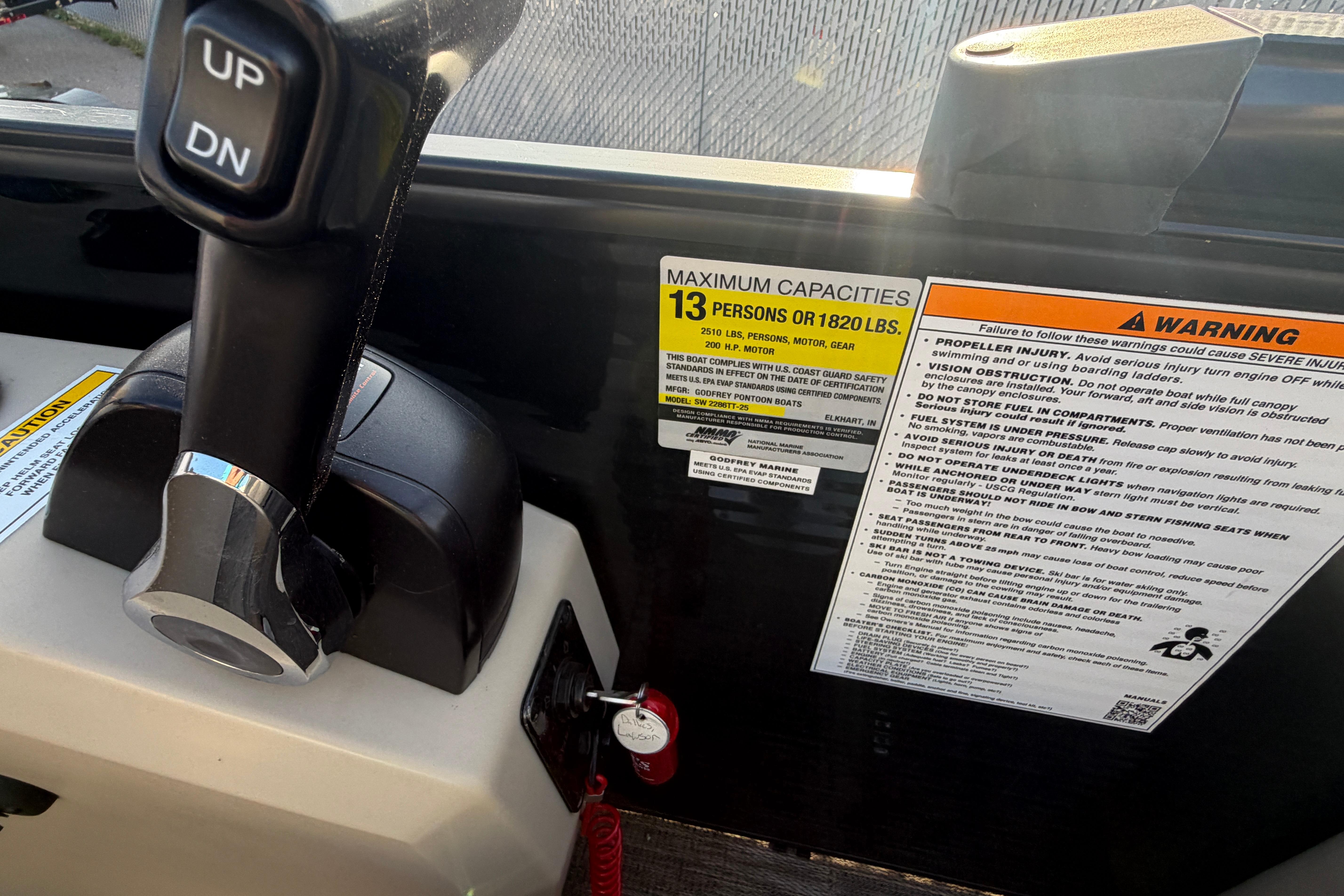 Control panel of 2023 Godfrey Sweetwater 2286 C boat with capacity and warning labels.