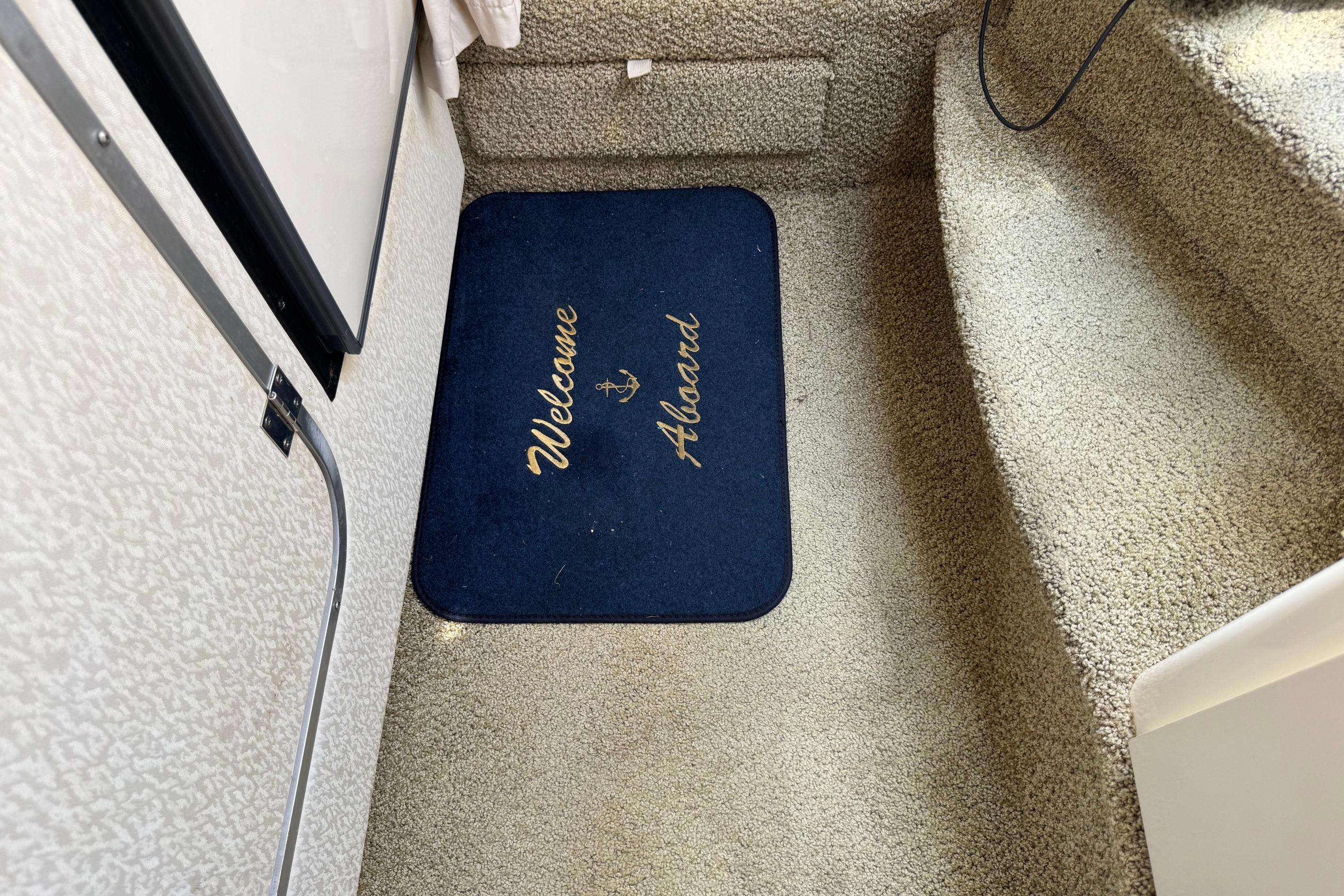 Welcome mat on Maxum 2400 SCR boat, 2000 model, with carpeted steps.