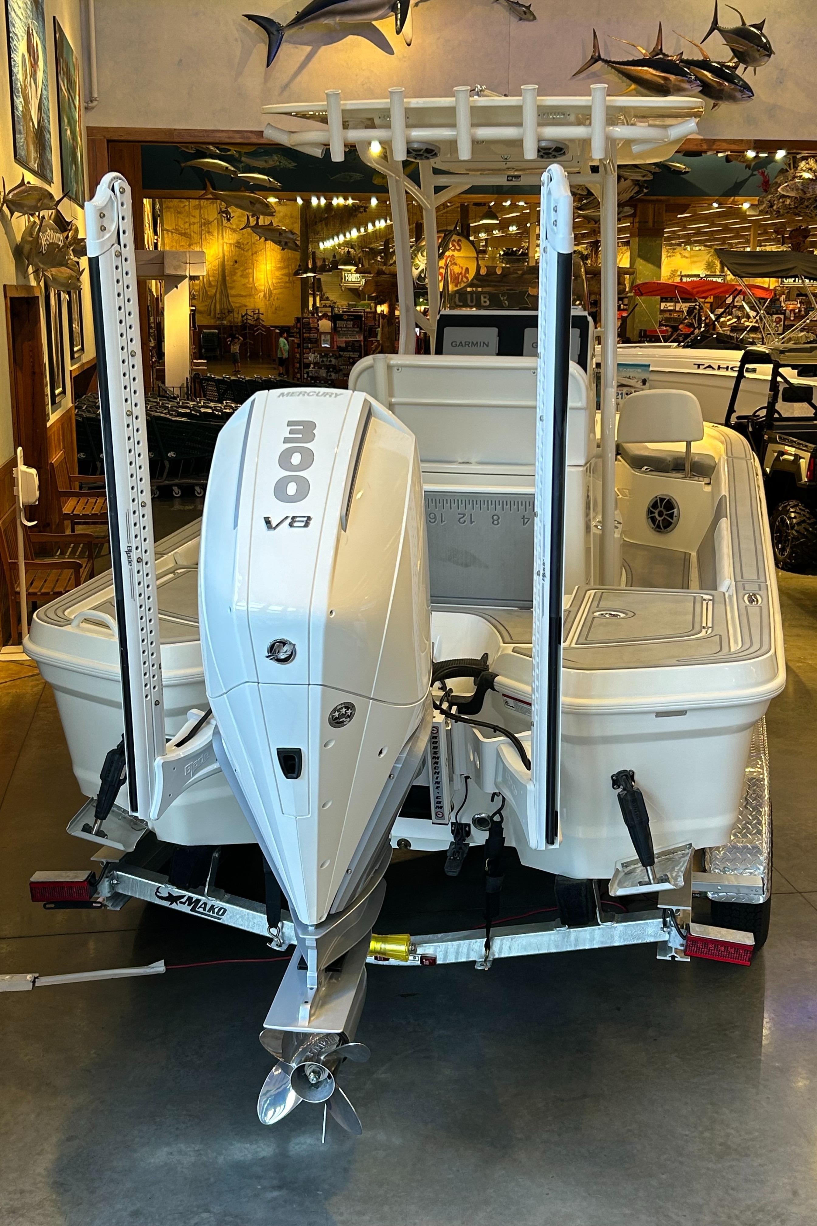 2025 Mako 24 APEX boat with 300 V8 engine displayed indoors.