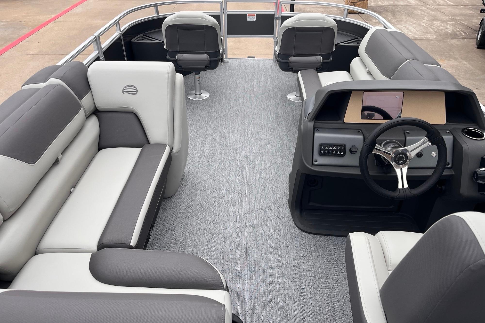 2026 Sun Tracker Fishin' Barge 20 DLX interior with seating and steering console.