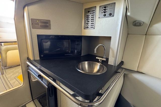 2008 Baja 30 Outlaw boat interior with kitchenette, featuring a microwave and sink.