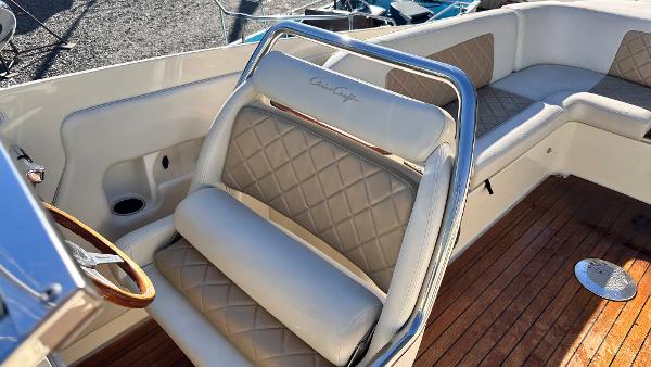 2014 Chris-Craft 28 LAUNCH boat interior with diamond-stitched seating and wooden deck.