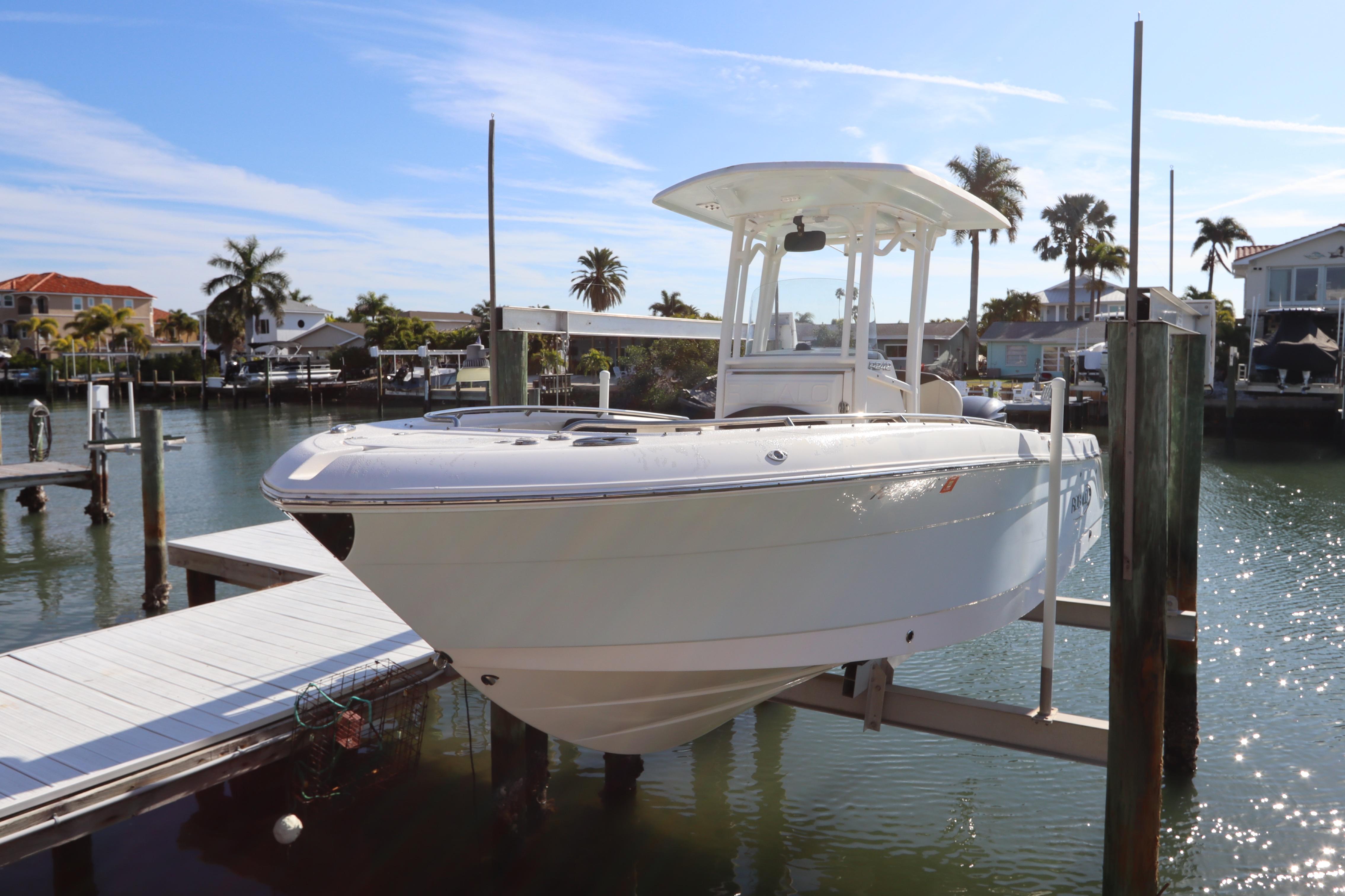 2019 Robalo R242 Center Console boat docked in a sunny marina setting.