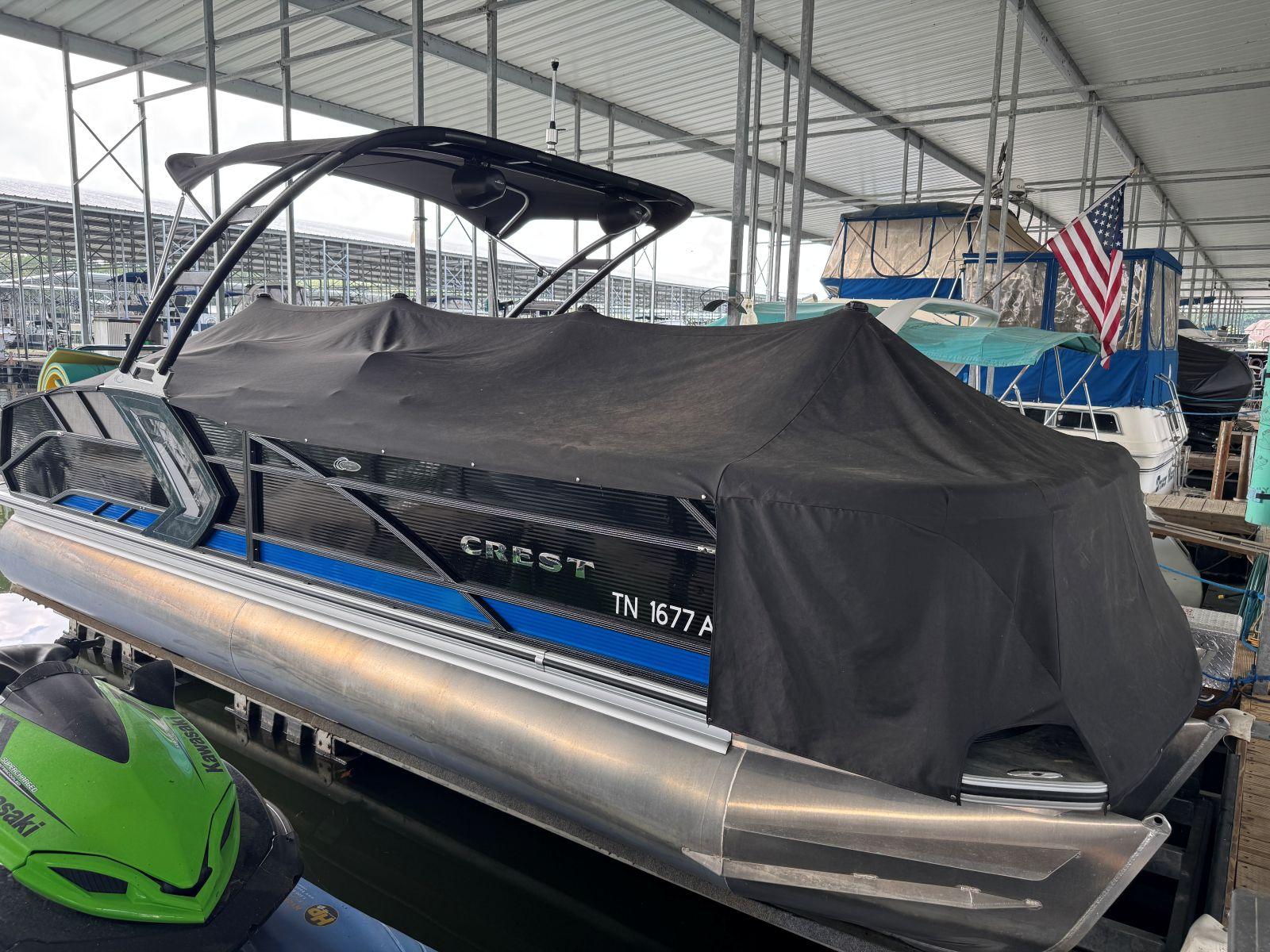 2022 Crest Caribbean RS 250 SLRC pontoon boat covered at marina dock.