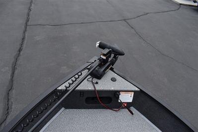 2026 Lowe Fishing Machine 1675 WT boat deck with trolling motor on pavement.