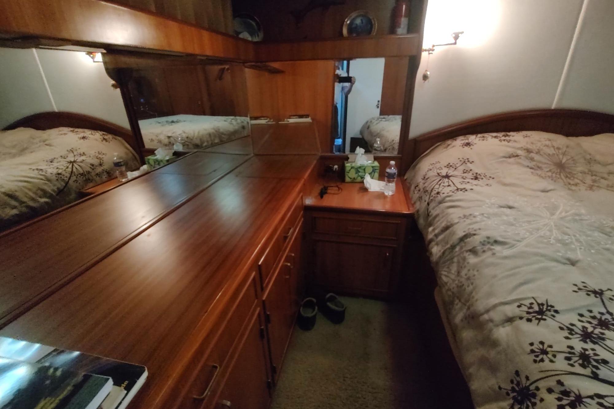 Luxurious 1989 Hyatt Double Cabin Motoryacht bedroom with wood furnishings and elegant bedding.