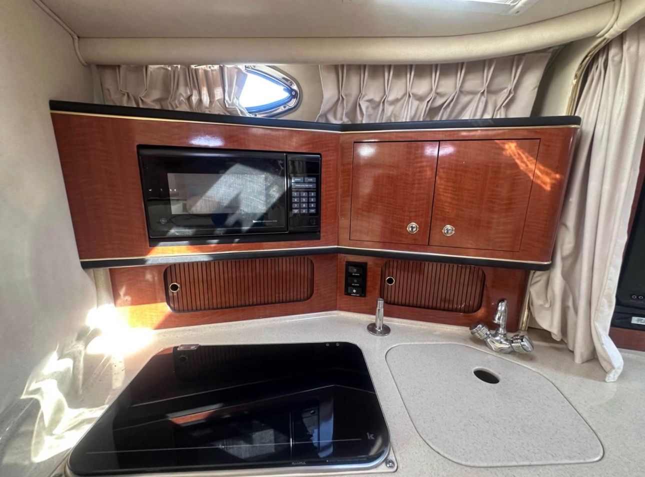 The galley of a 2002 Sea Ray 300 Sundancer with a microwave and sink.