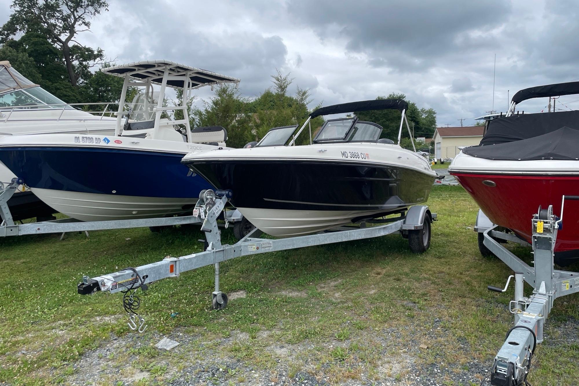 2023 Bayliner VR4 Bowrider OB on trailer, parked outdoors among other boats.