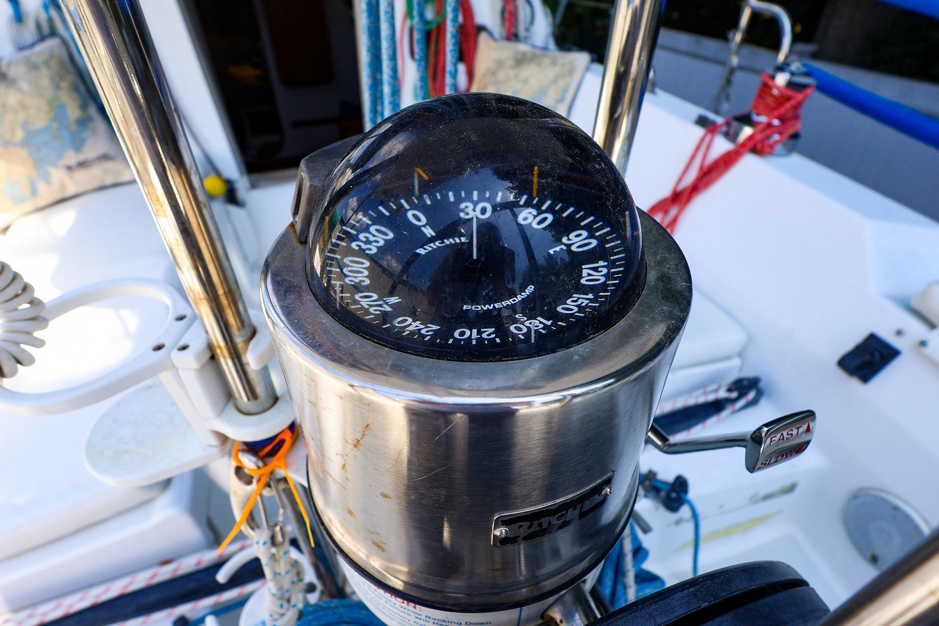 Compass on a 2001 J Boats J/32 sailboat cockpit, featuring nautical ropes and controls.