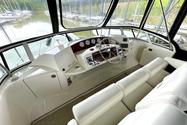 2002 Silverton 43 Motor Yacht helm with white seating and panoramic windows.