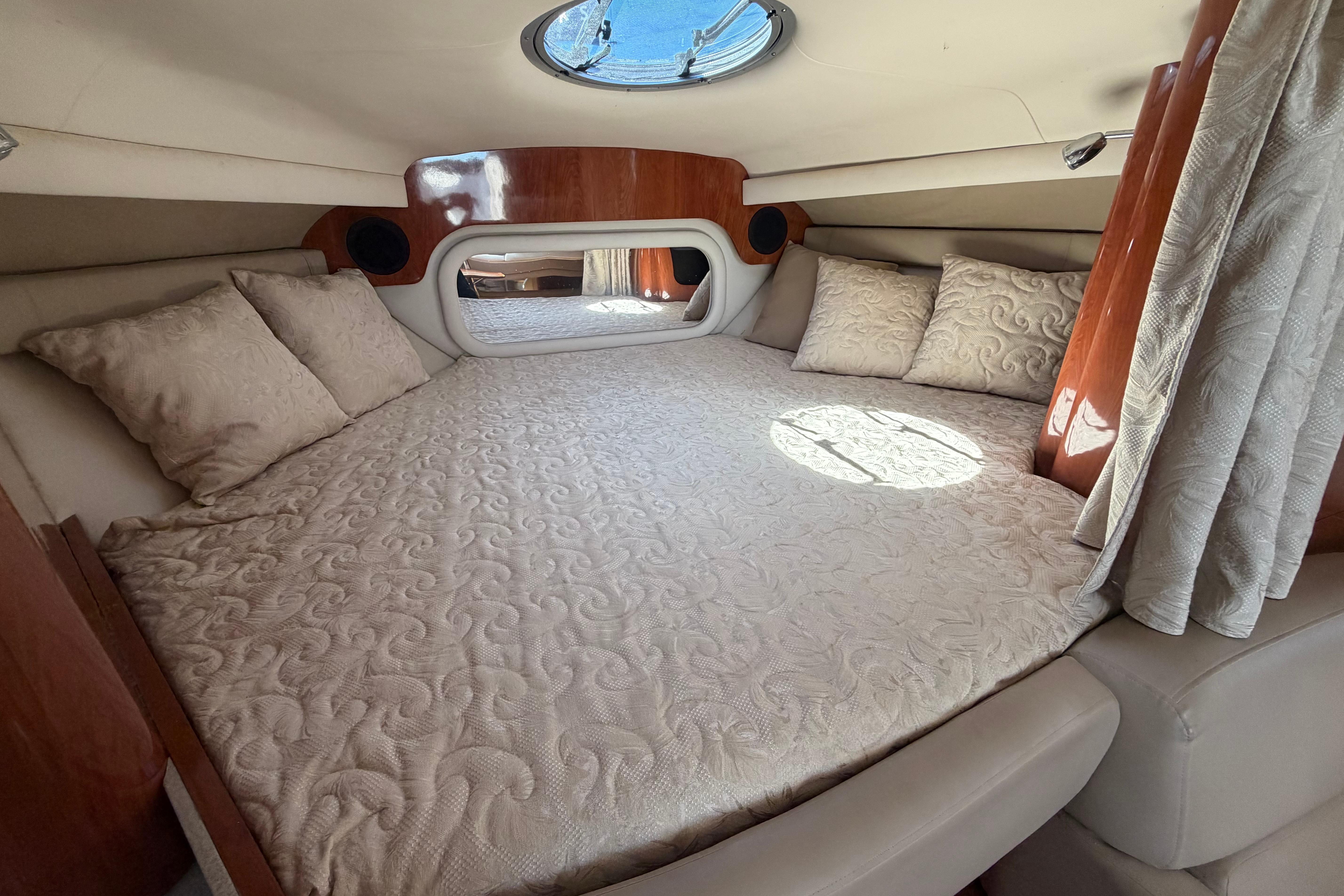 Luxurious cabin interior of 2008 Crownline 340 CR yacht with plush bedding and pillows.