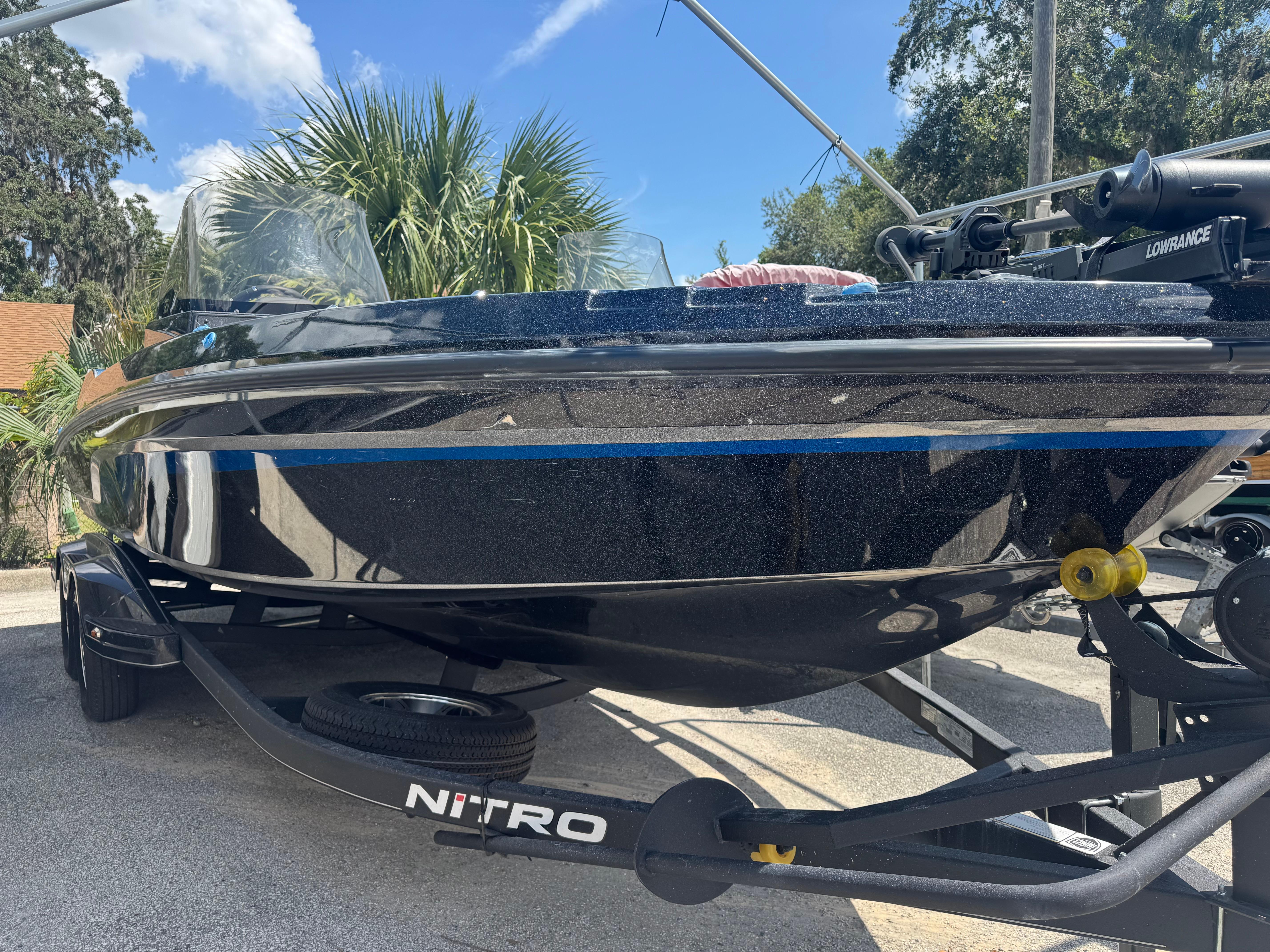 2024 Nitro ZV21 boat on trailer, parked outdoors under clear blue sky.