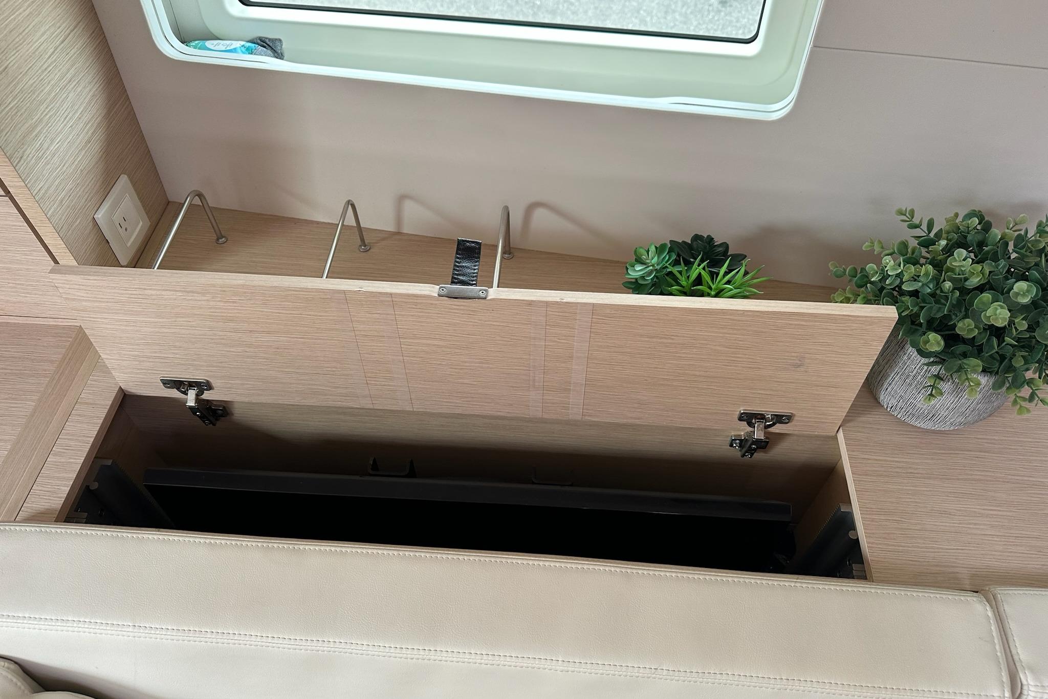 Interior of 2018 Jeanneau 51 yacht with storage compartment and decorative plants.