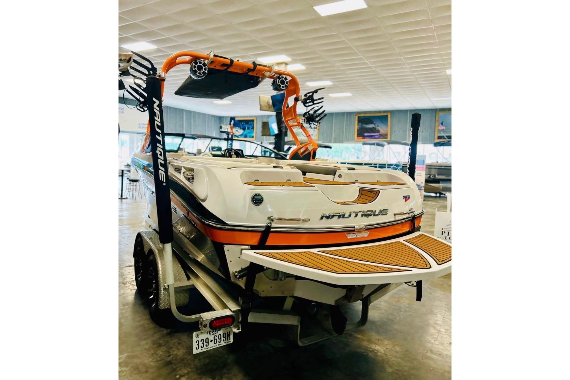2013 Nautique Super Air Nautique 230 boat in showroom, rear view with wakeboard tower.