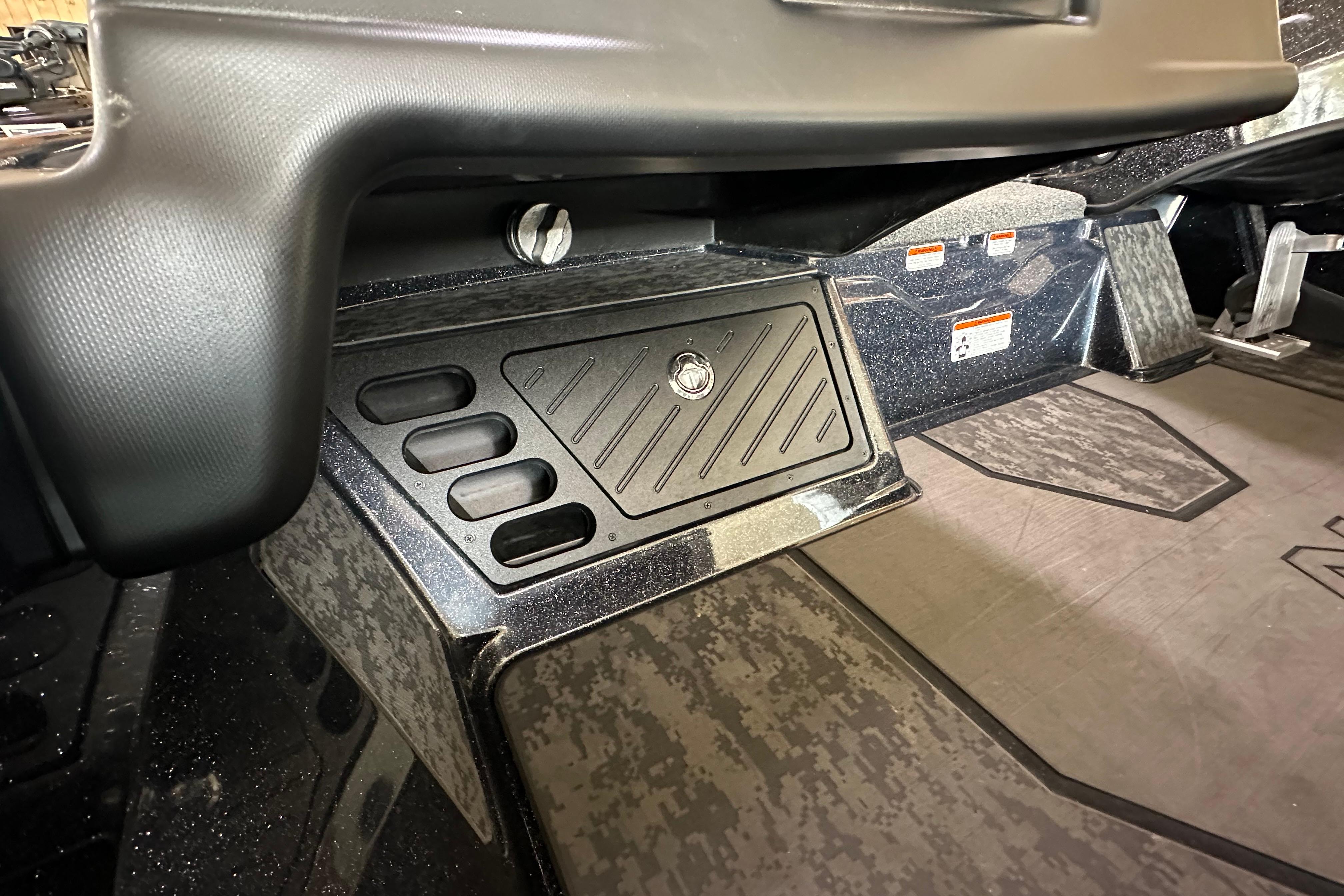 Interior view of 2025 Nitro Z20 XL Pro boat, featuring storage compartments and textured flooring.