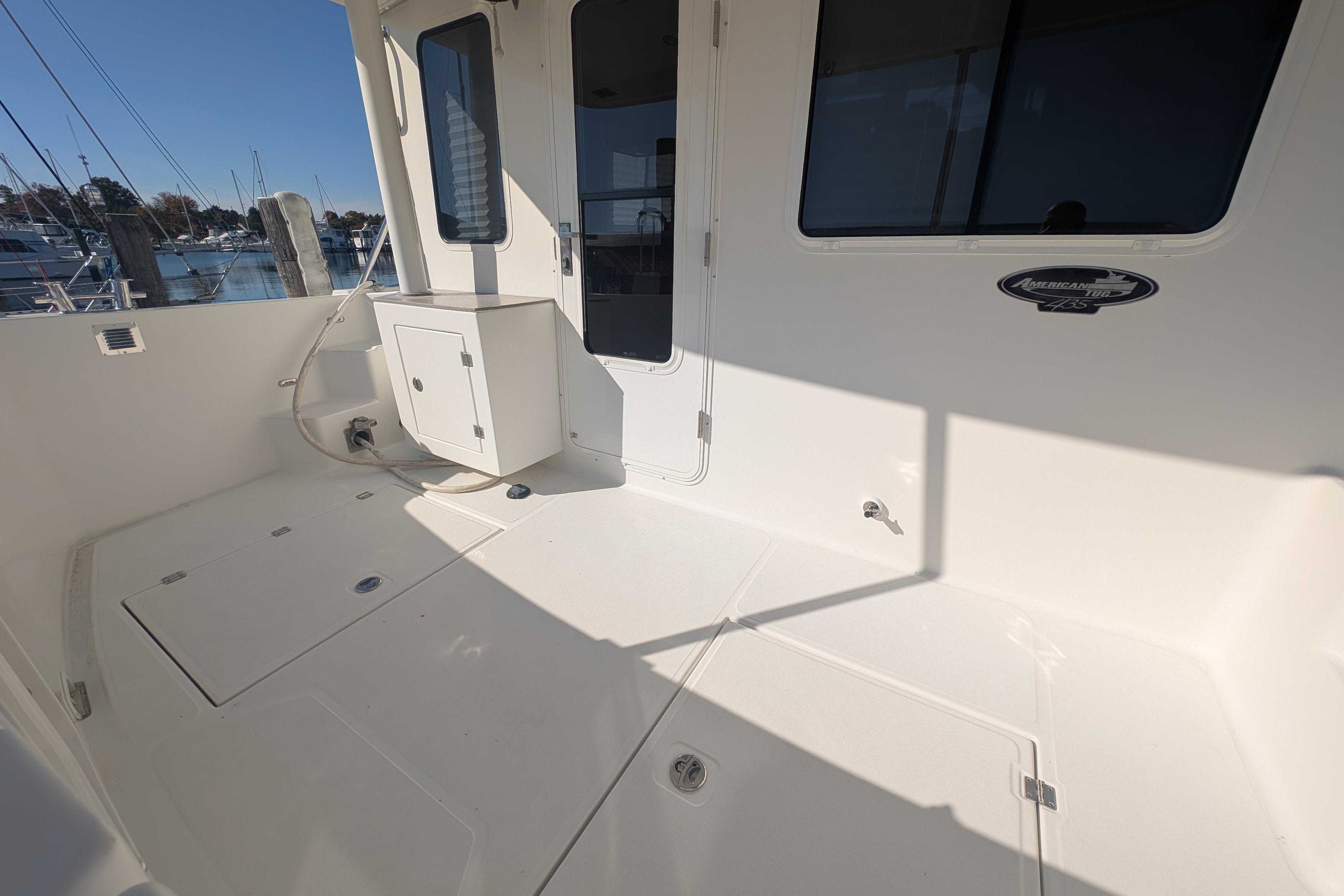 2015 American Tug 435 boat deck with storage compartments and marina view.