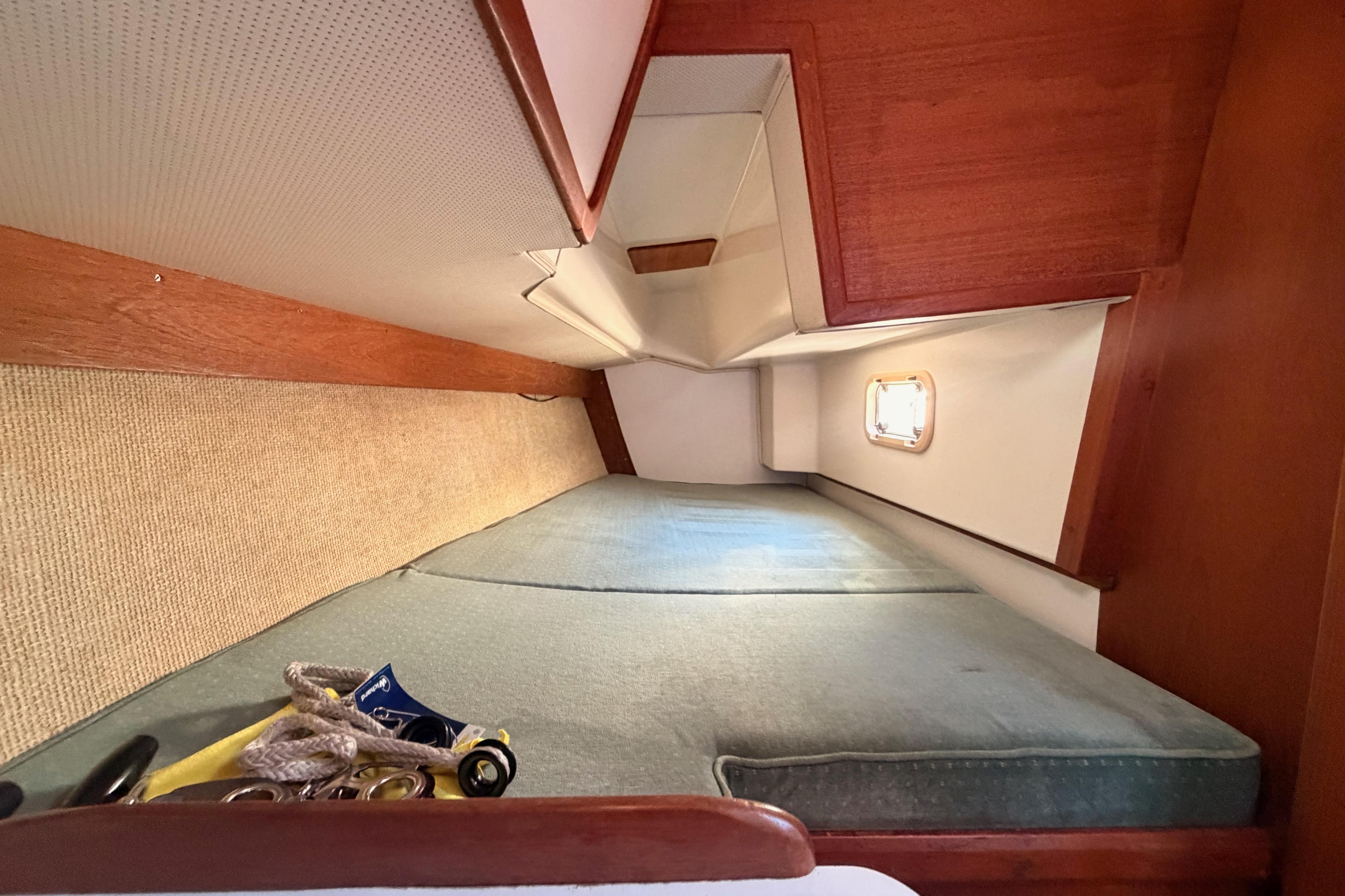 Interior cabin of a 1991 Caliber 33 sailboat with a cozy sleeping area.