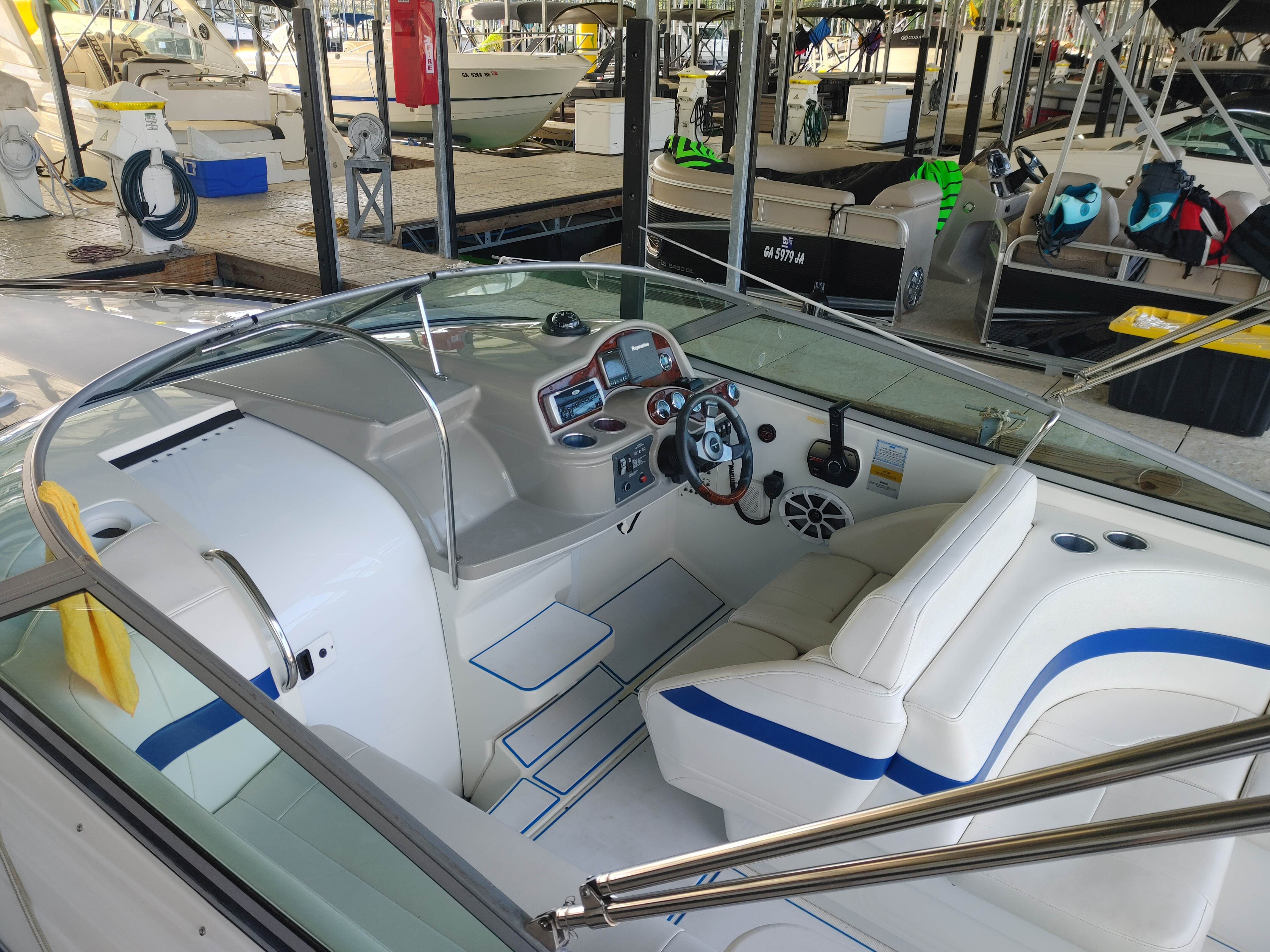 The image shows the cockpit of a 2003 Formula 260 Sun Sport boat in a marina.