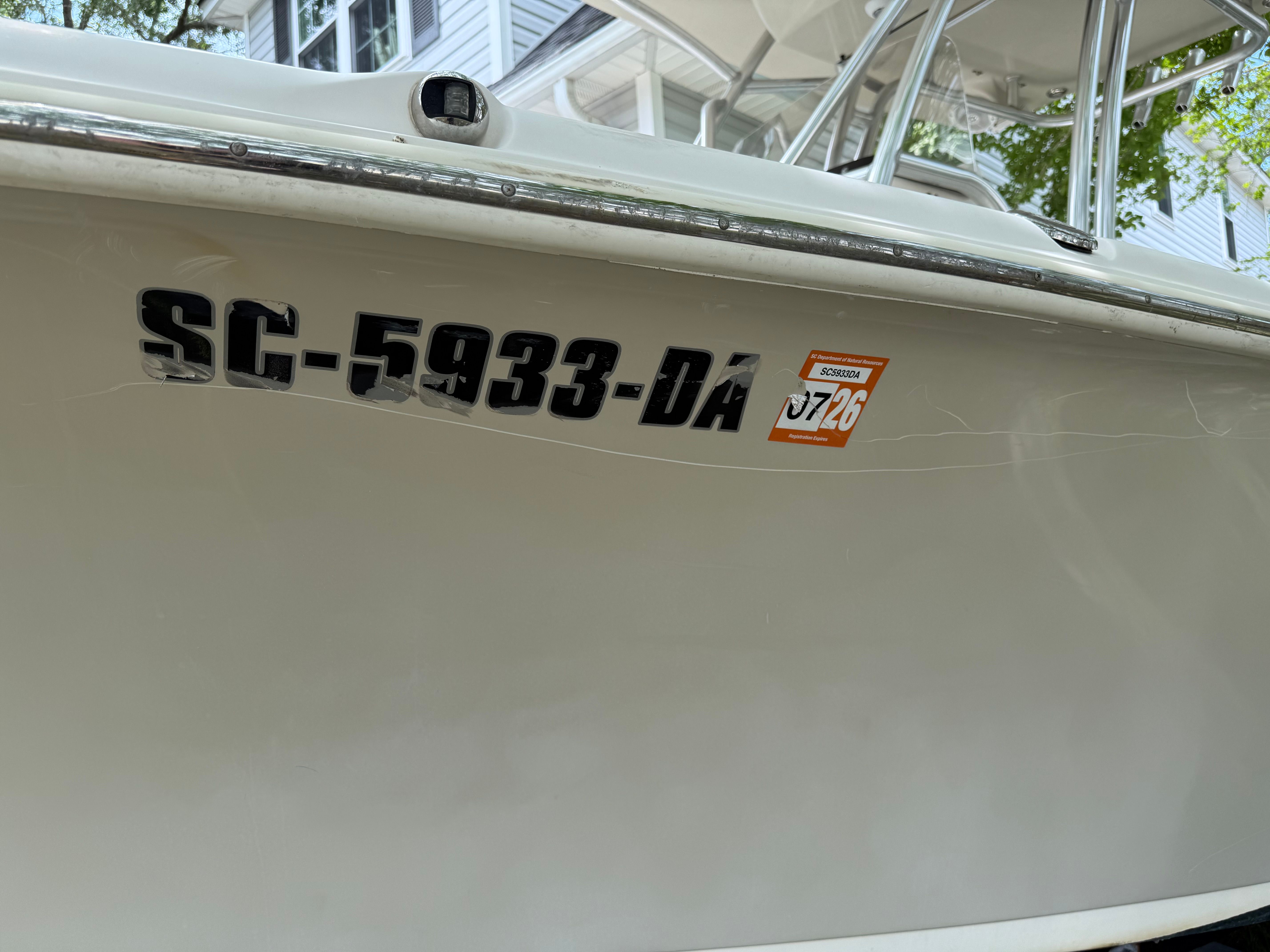 Close-up of boat side with registration number and sticker.