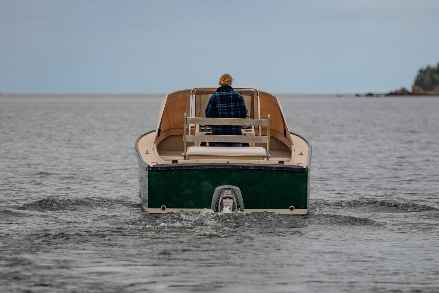A person navigates an Ellis 24 Open boat from 1989 on calm waters.