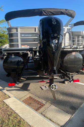 2024 Ranger Reata 223C boat with powerful outboard motor, parked on a sunny day.