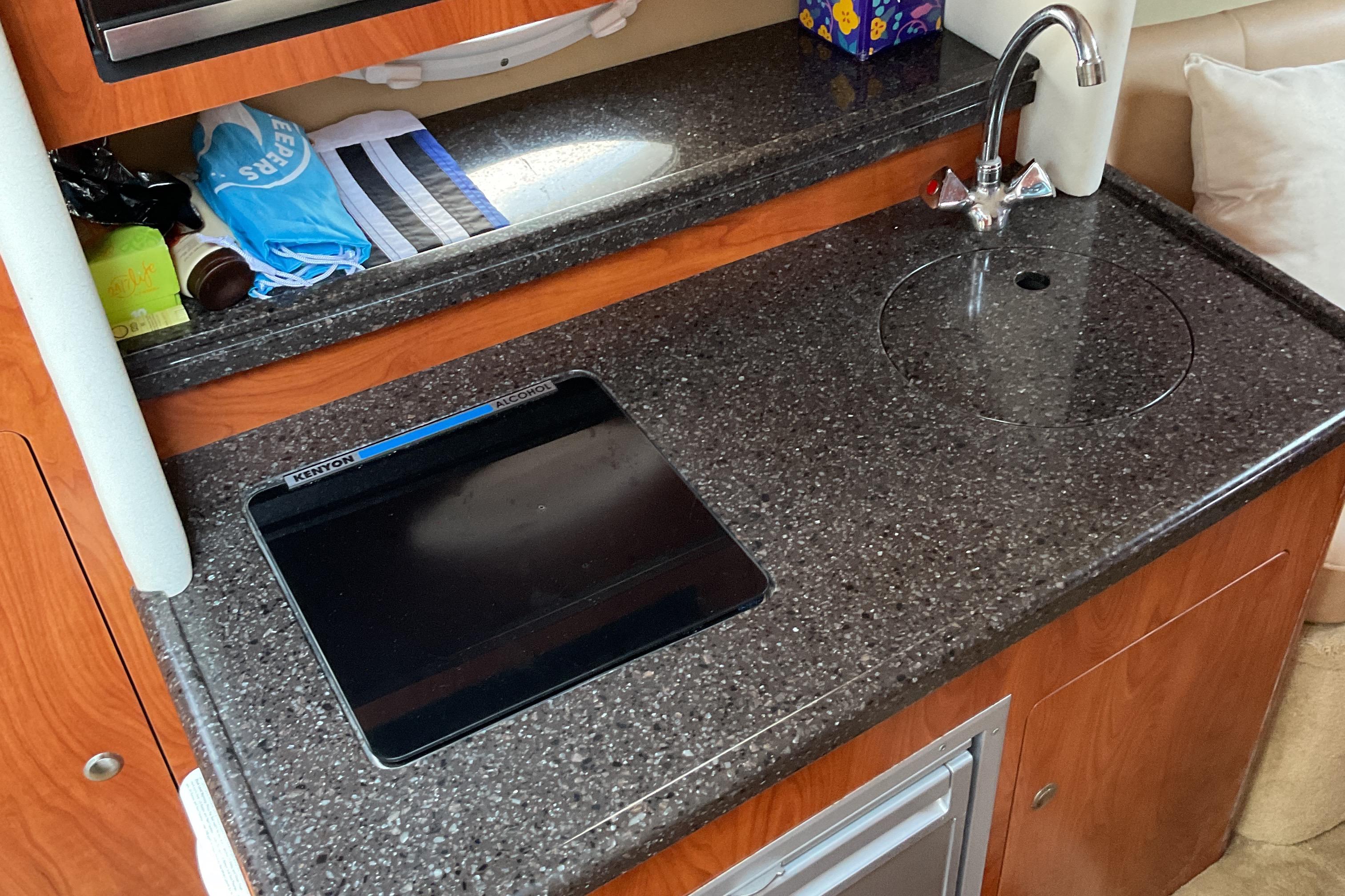 2013 Rinker 290 Express Cruiser kitchen with sink and countertop.