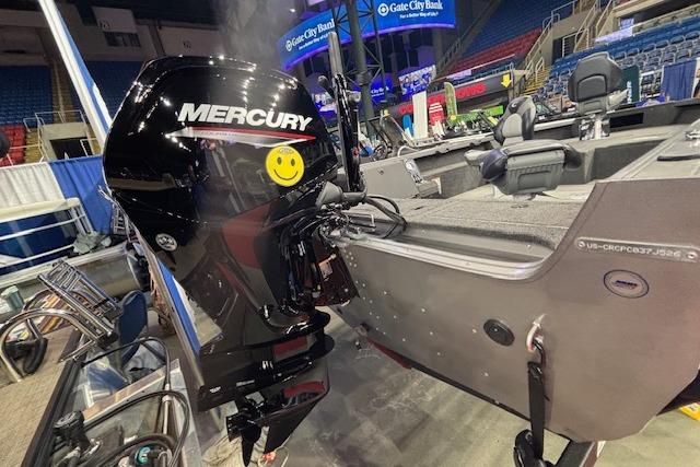 2026 Crestliner 1850 Pro Tiller boat with Mercury outboard motor at indoor exhibition.