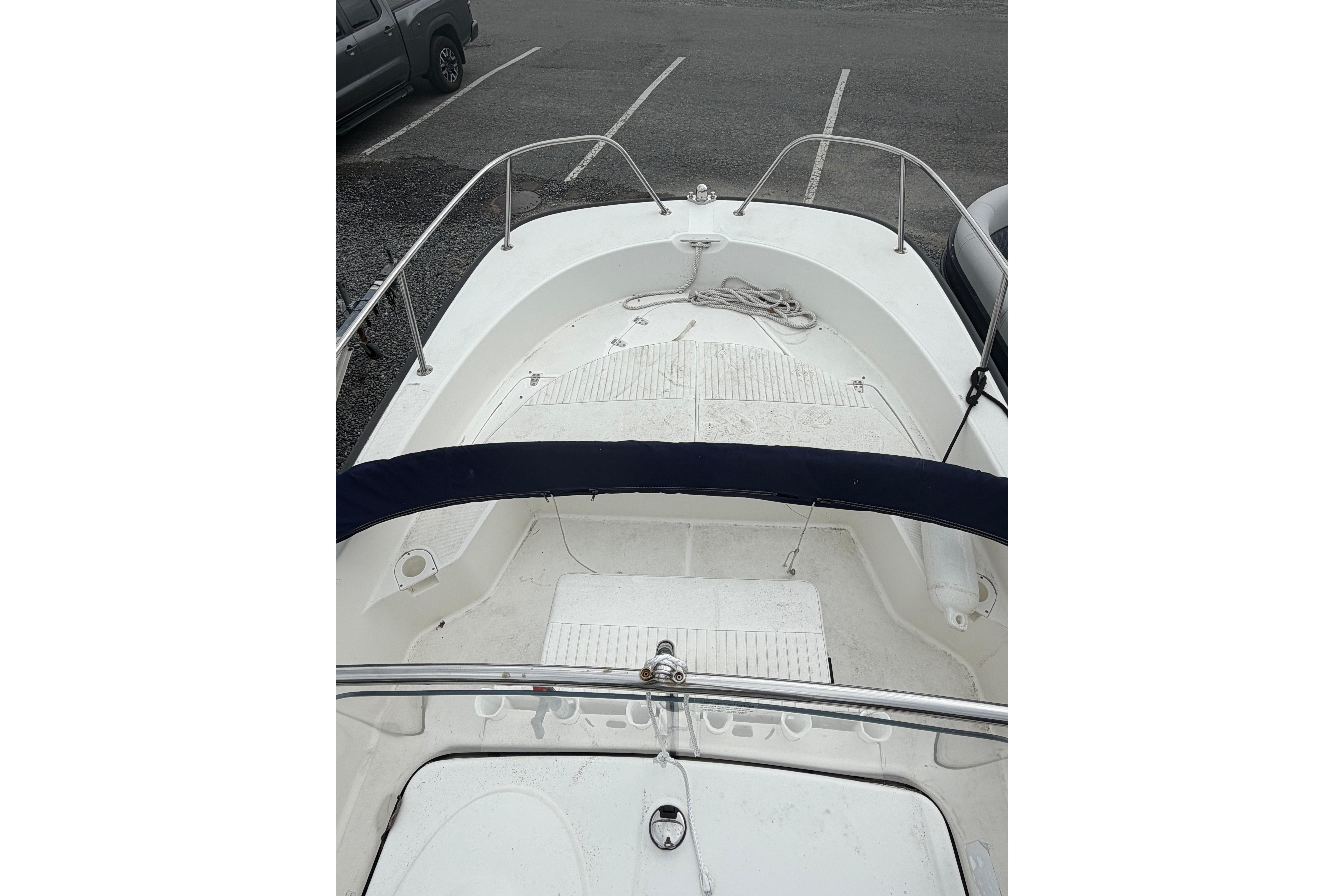 2015 Boston Whaler 210 Montauk boat interior with seating and railing, parked in a lot.