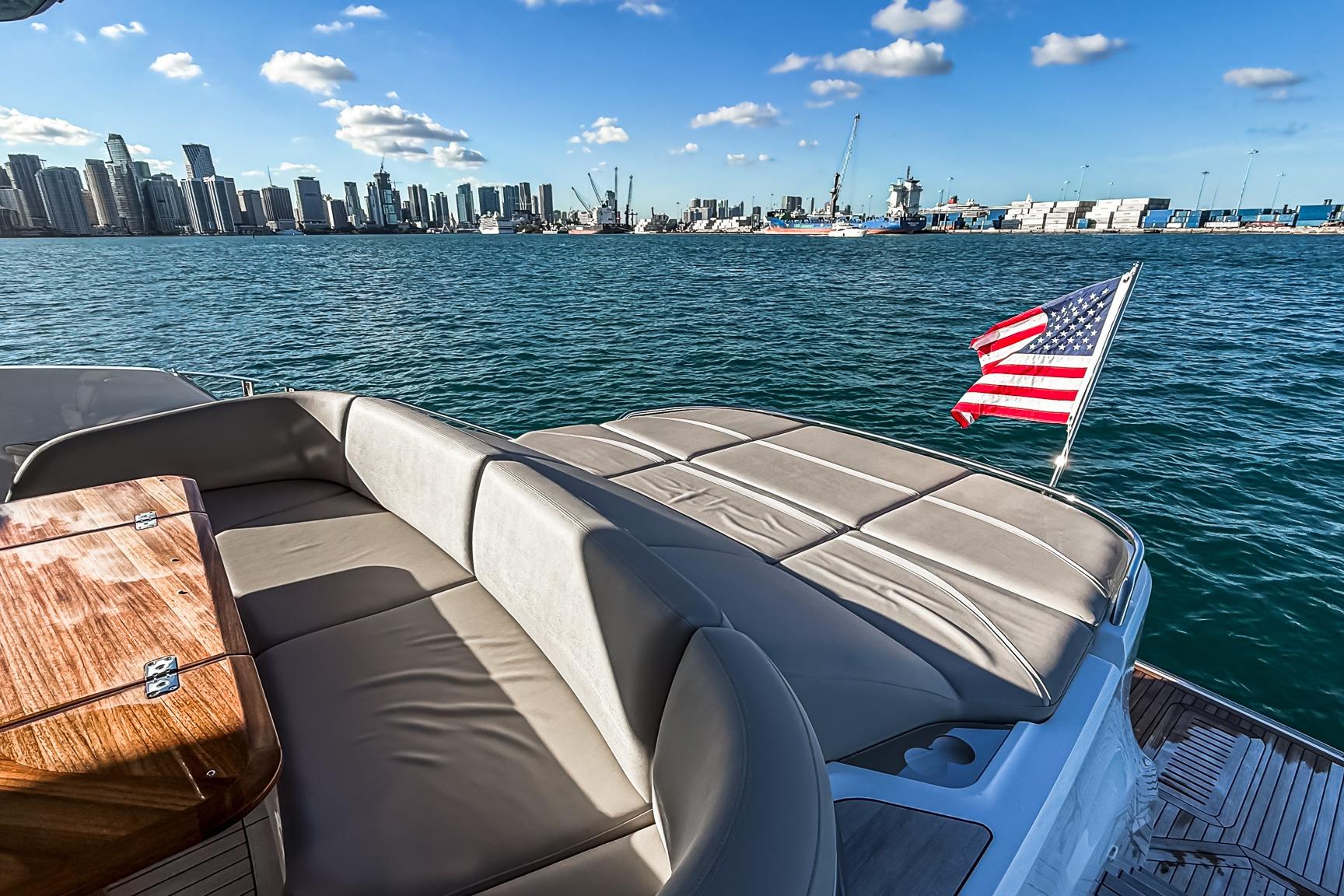 Luxurious 2026 Princess S65 Sportbridge yacht with city skyline and American flag.