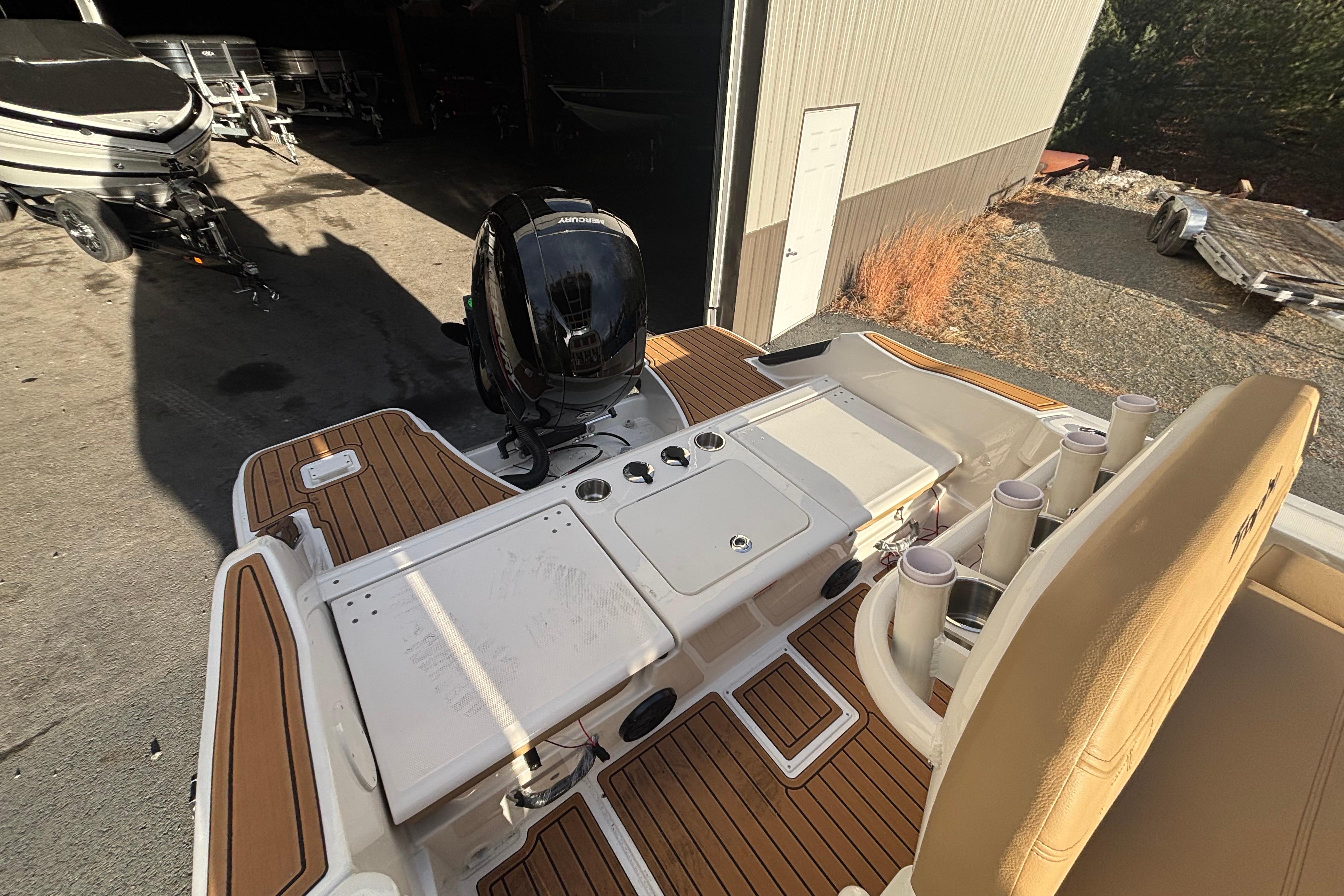 2026 Bayliner Trophy T20CC boat with outboard motor and teak deck in a garage.