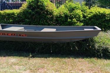 2026 Tracker Grizzly 12 Jon boat displayed outdoors against greenery.